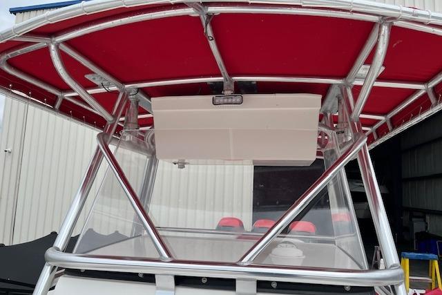2001 Fountain 38 Center Console boat with red canopy and metal frame.