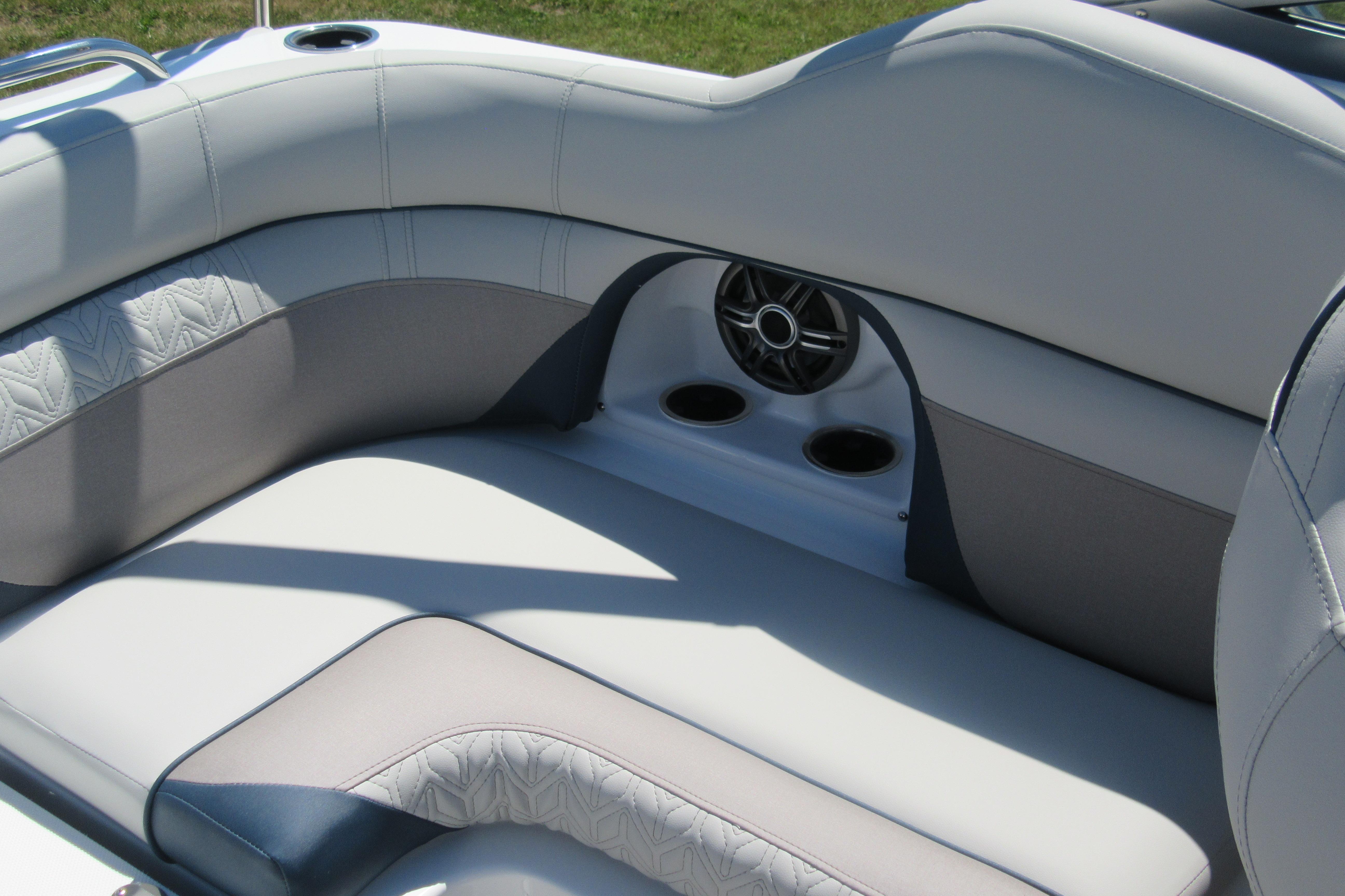 2027 Hurricane SunDeck 2486 OB boat interior with cushioned seating and built-in speakers.