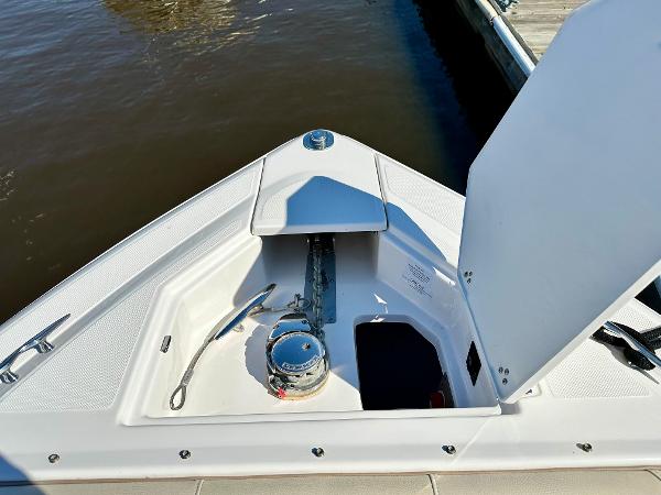 The bow of a boat with an anchor and storage compartment is visible.