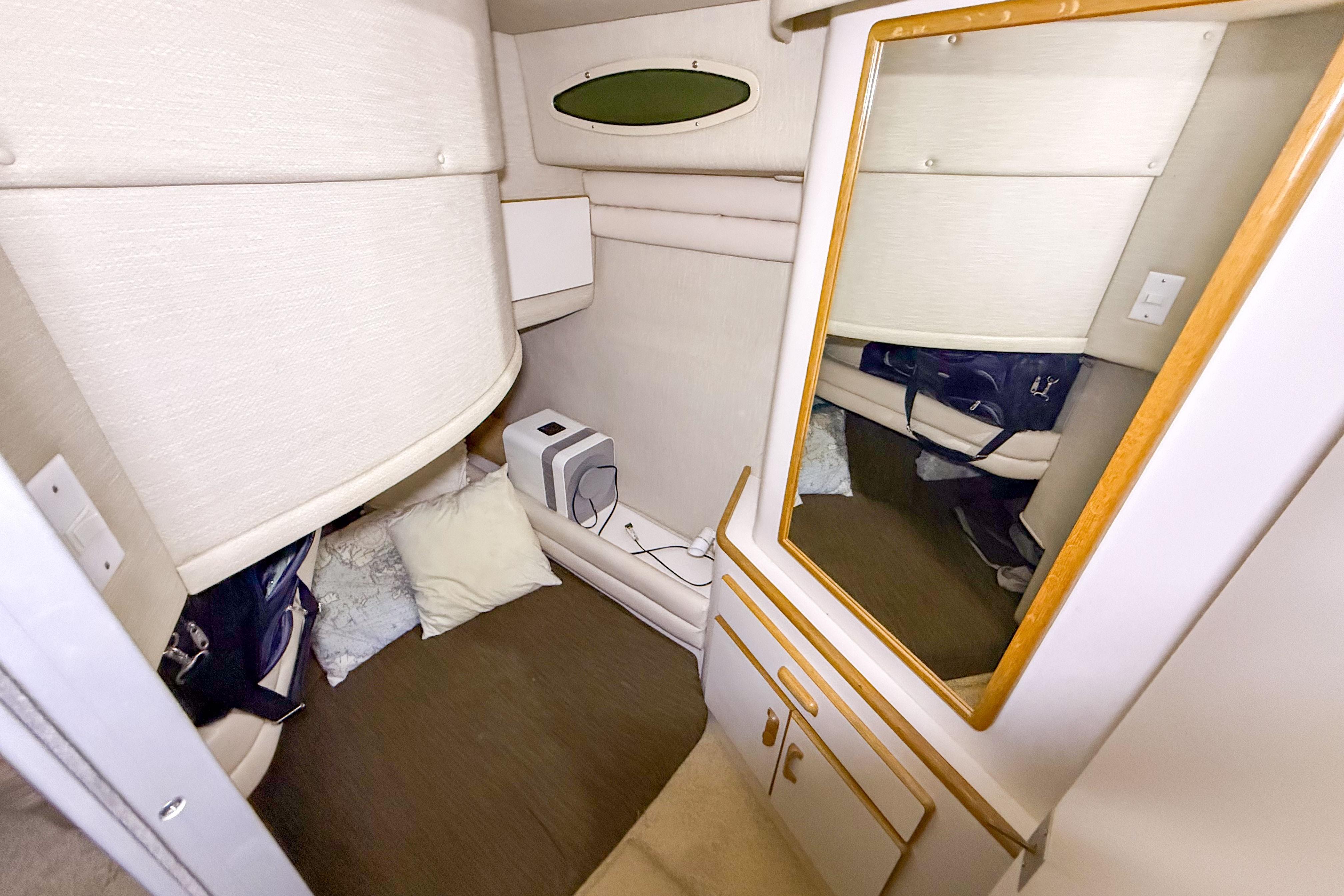 Interior cabin of 1995 Sea Ray 370 Sedan Bridge with mirror and cozy seating area.