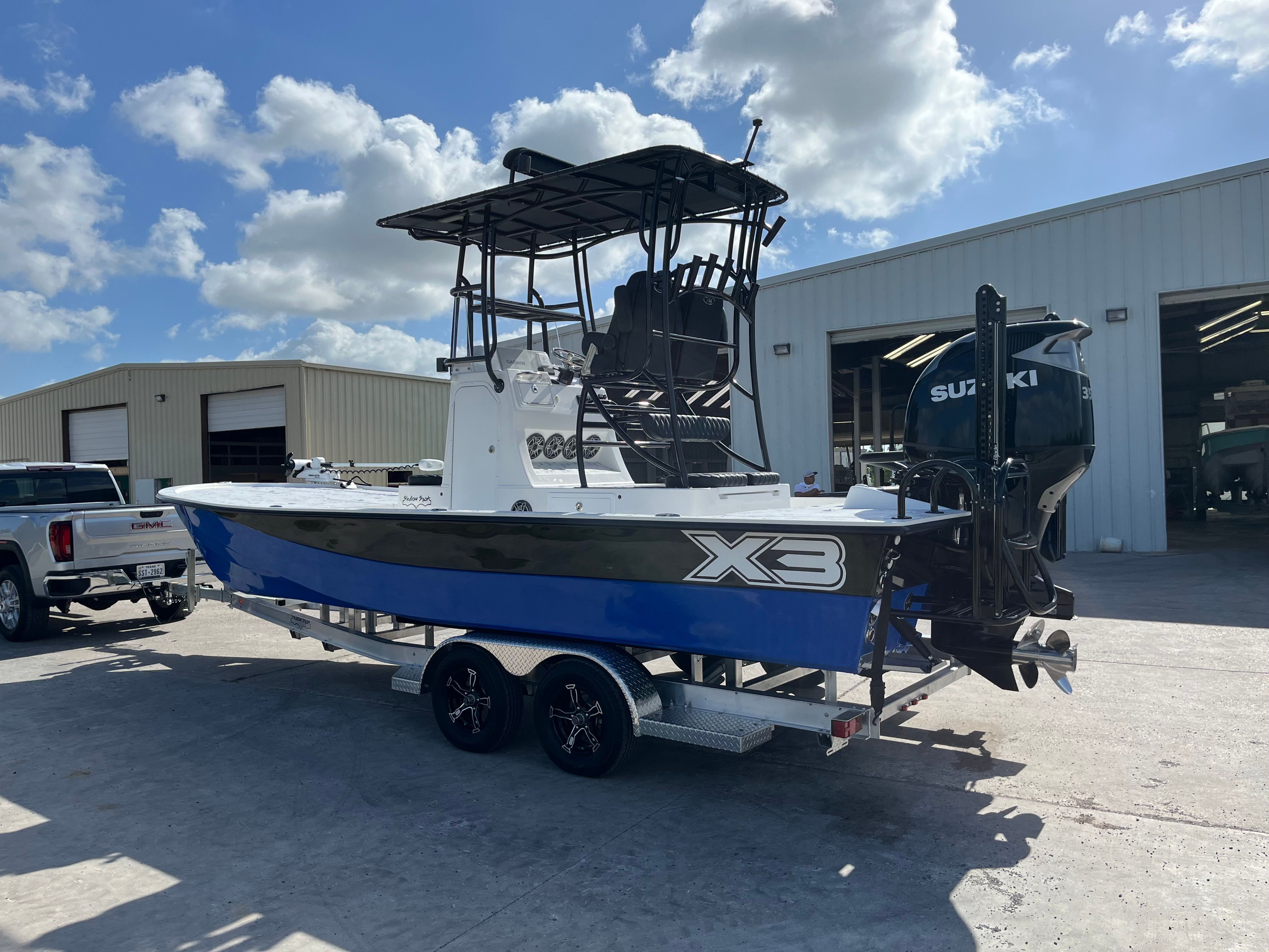 2023 Shallow Sport 25 X3 boat on trailer outside warehouse.