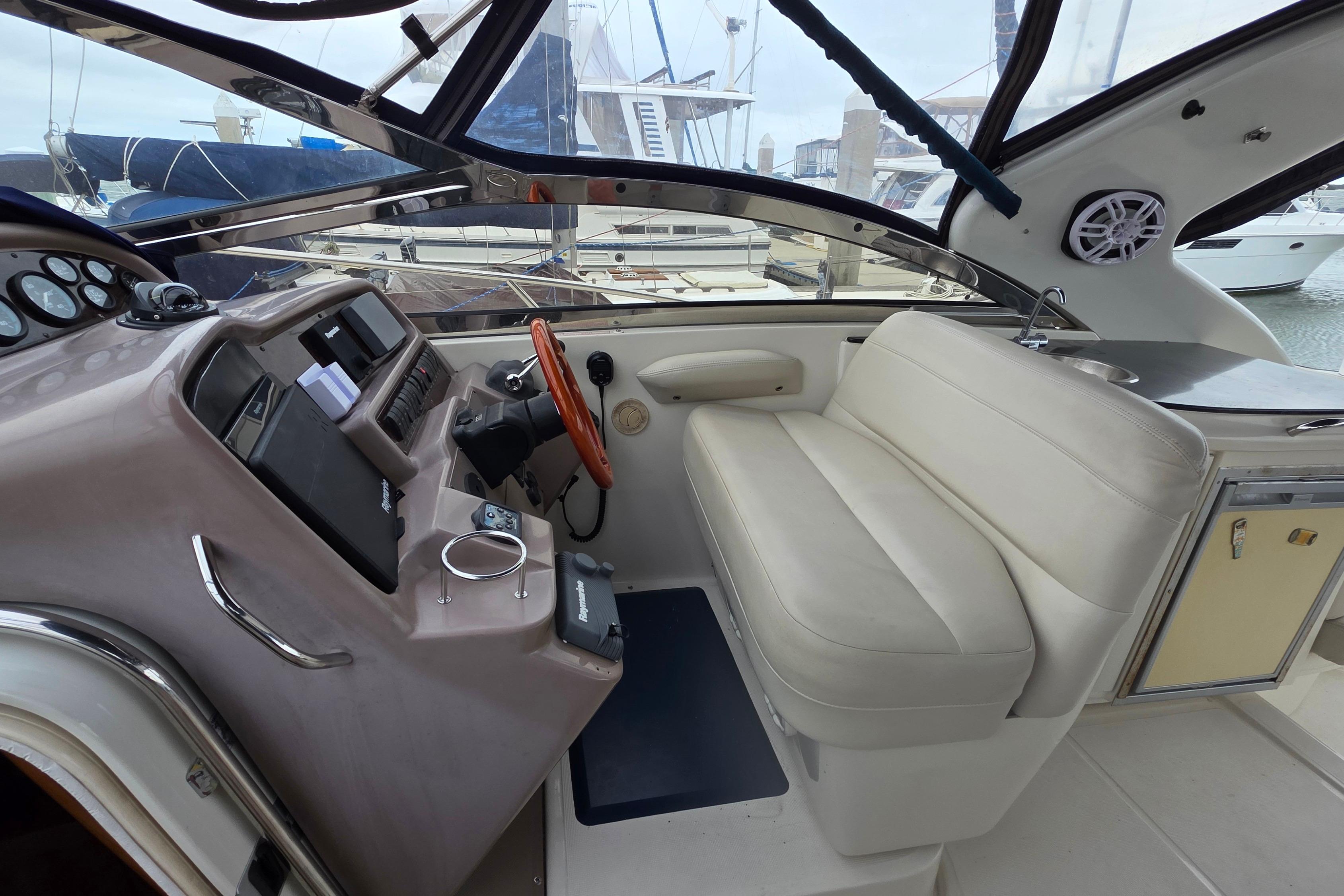 2002 Regal Commodore 4260 yacht interior with helm, seating, and marina view.