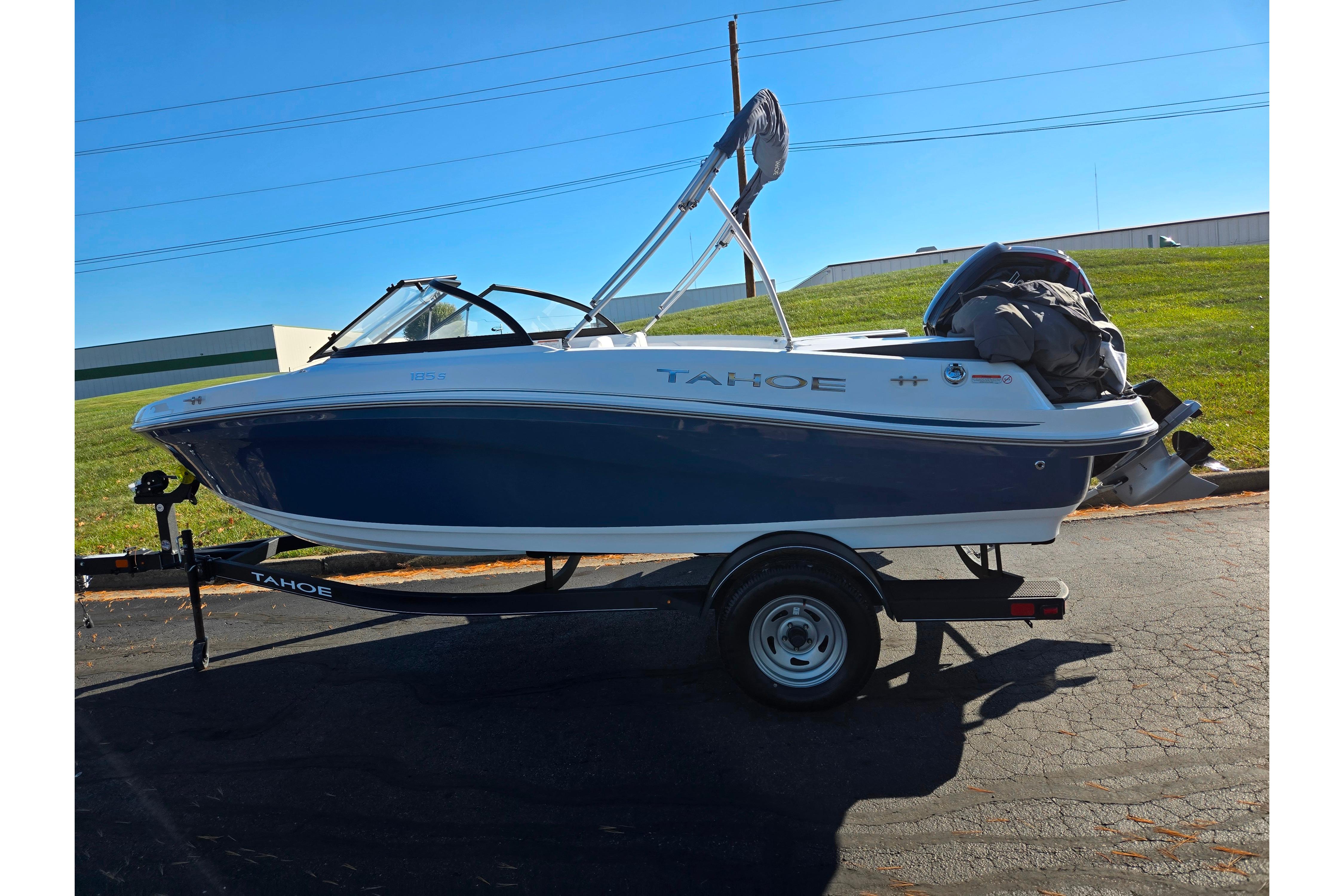 2023 Tahoe 185 S boat on trailer, parked outdoors under clear blue sky.