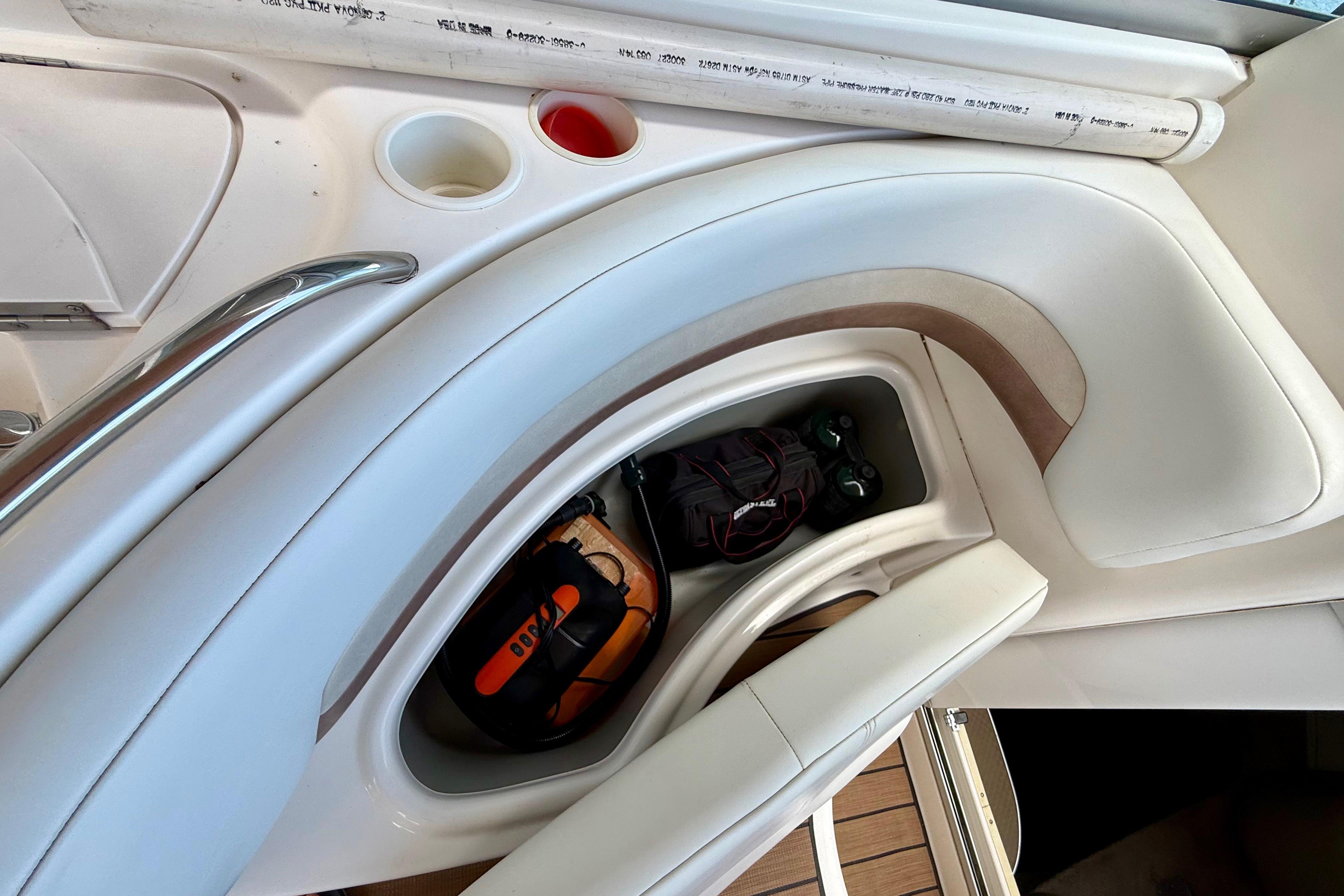 Interior storage compartment of 1999 Chaparral Signature 300 boat with gear and accessories.