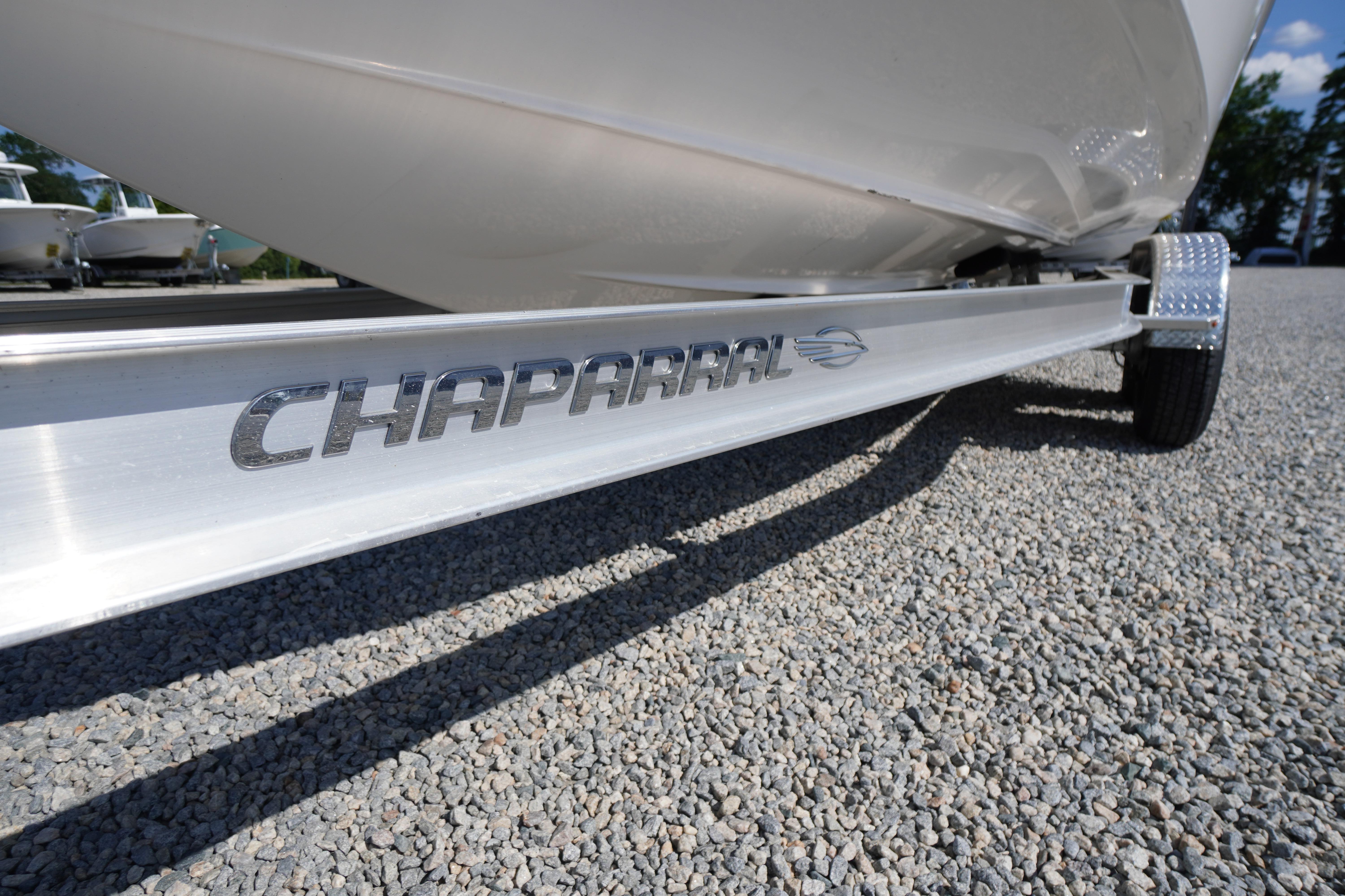 2026 Chaparral 270 OSX boat trailer on gravel, showcasing brand logo.