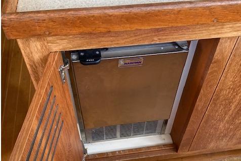 Wooden cabinet with a built-in marine refrigerator on a 2000 Mainship 430 Trawler.
