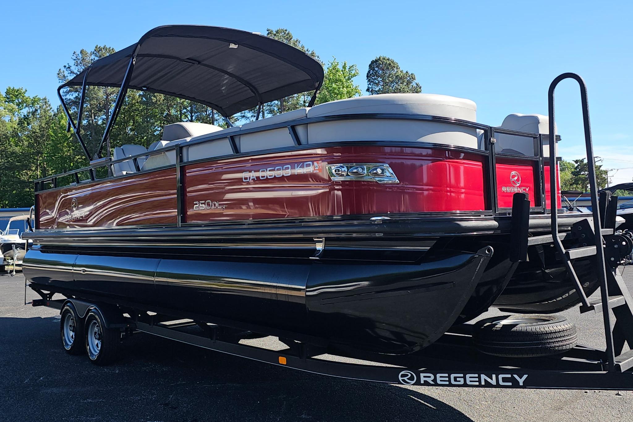 2023 Regency 250 DL3 pontoon boat with red exterior on a trailer.
