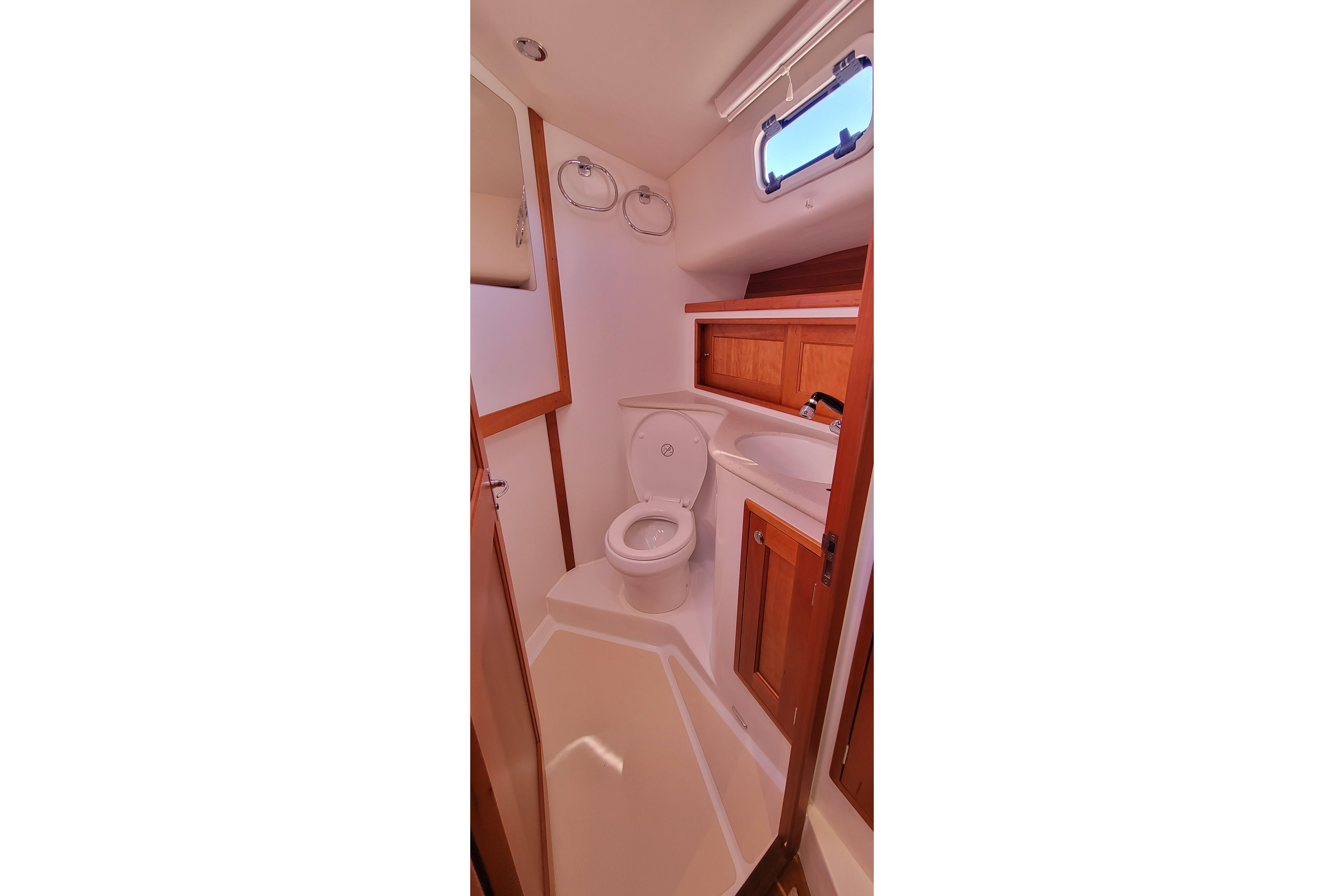 2017 MJM 40z Downeast yacht bathroom with wooden cabinets and compact design.