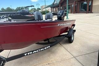2025 Tracker Super Guide V-16 T boat on trailer, parked outdoors.