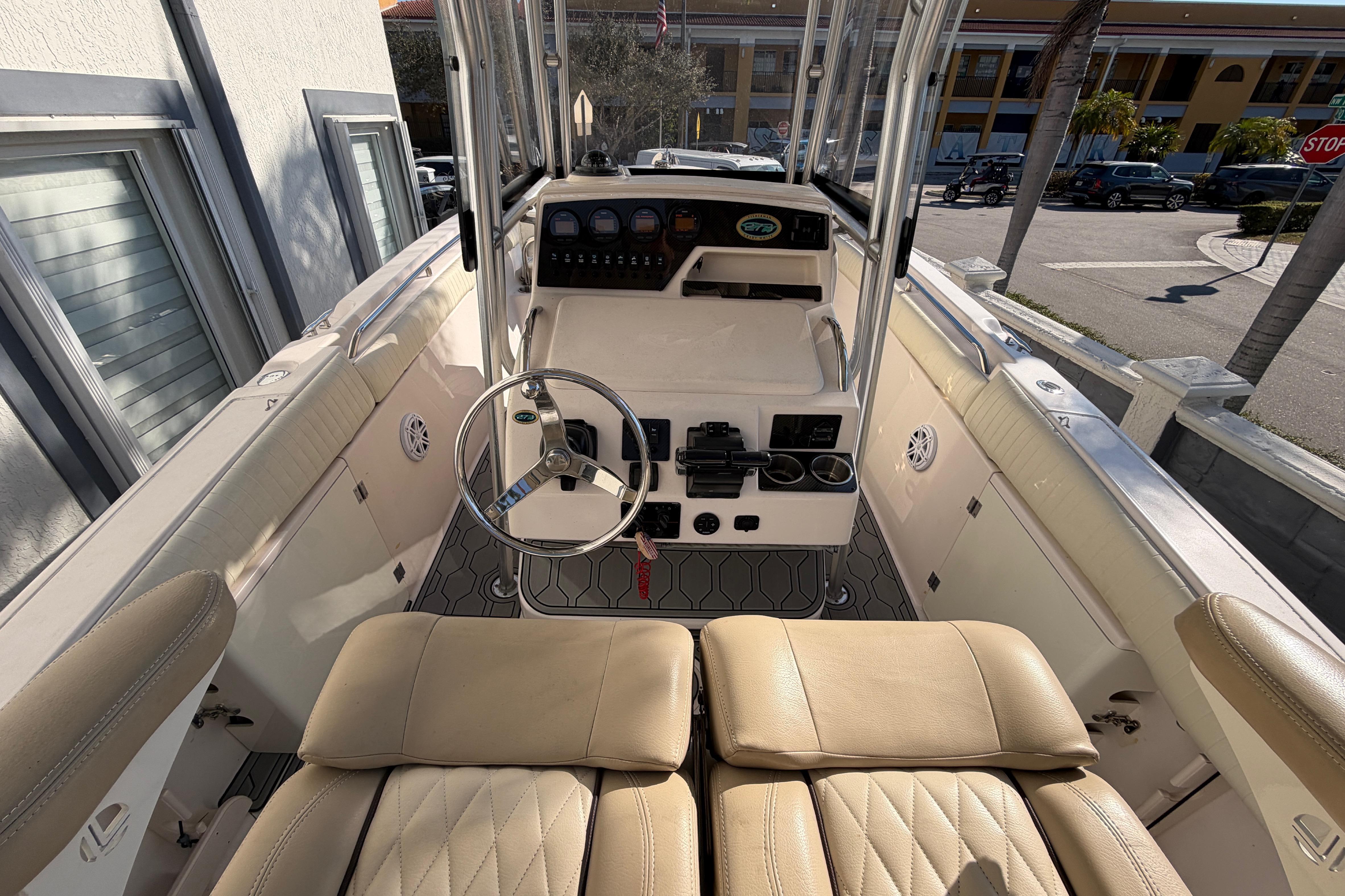 2004 Grady White 273 boat interior with steering wheel and seating area.