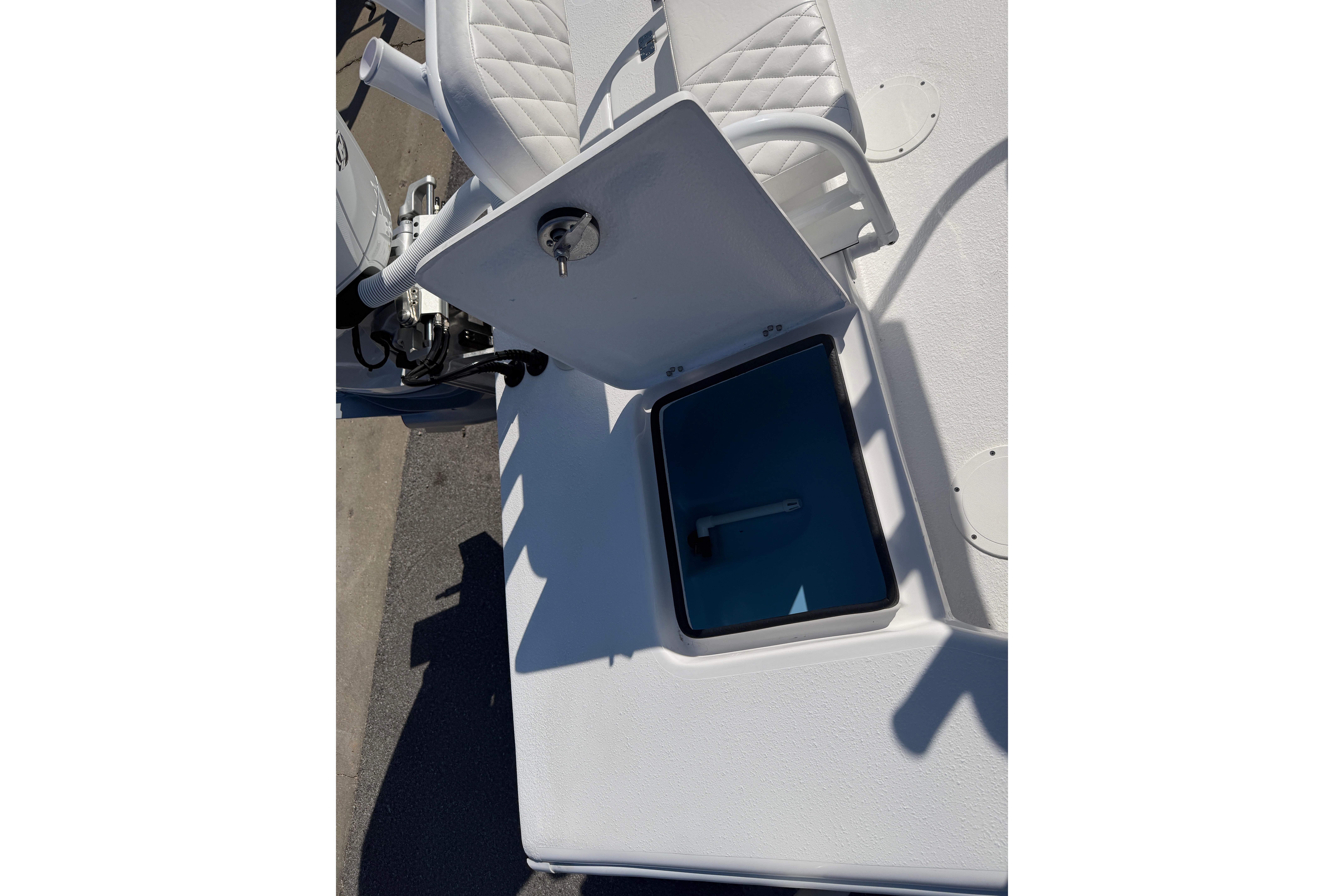 2026 Skuta 24 Cat boat with open storage compartment and white seating.