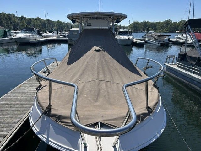 2000 Aquasport Osprey 250 docked with a cover on the deck.