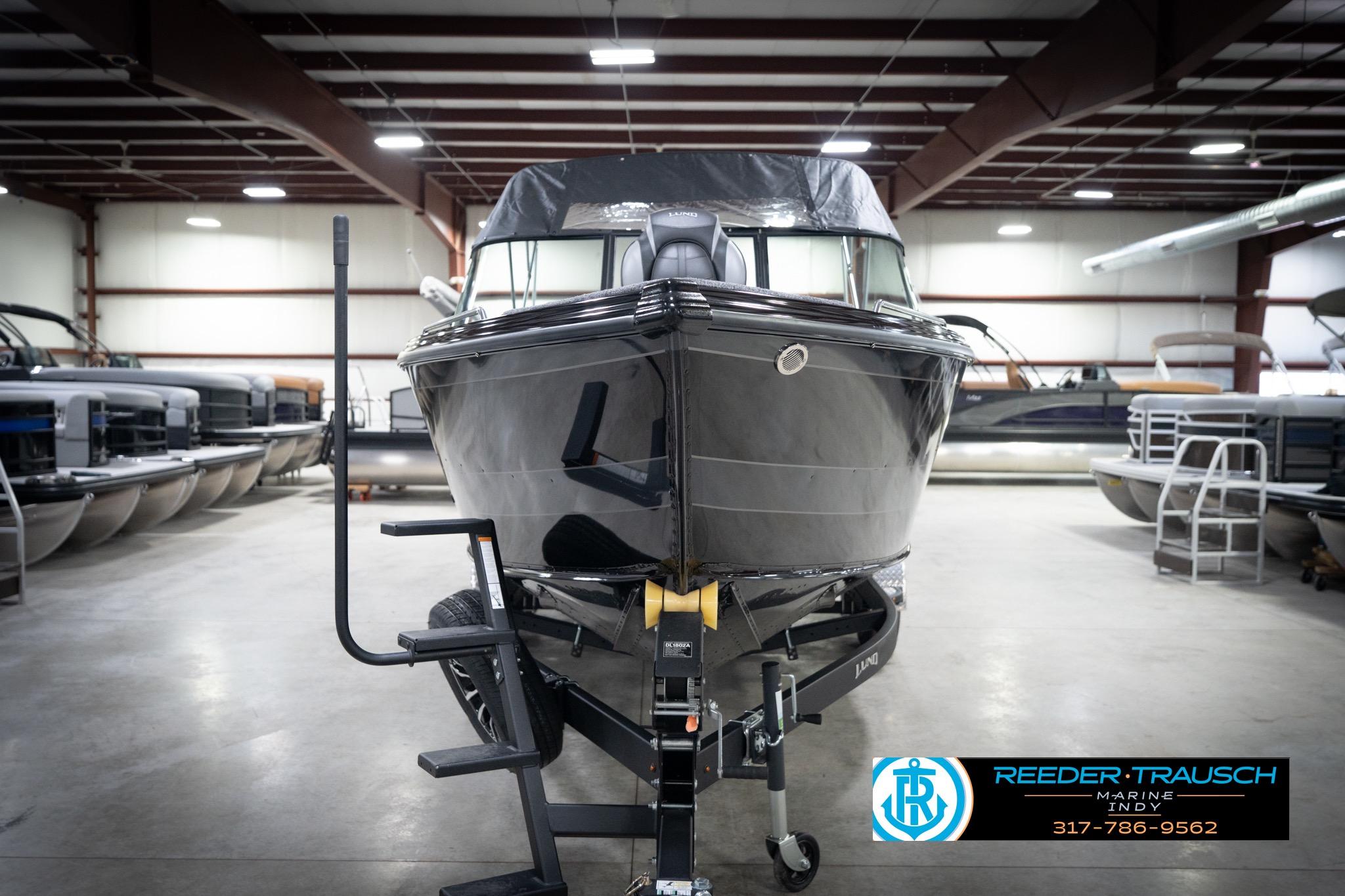2026 Lund 2275 Baron boat in showroom, front view, on trailer, Reeder-Trausch Marine logo visible.