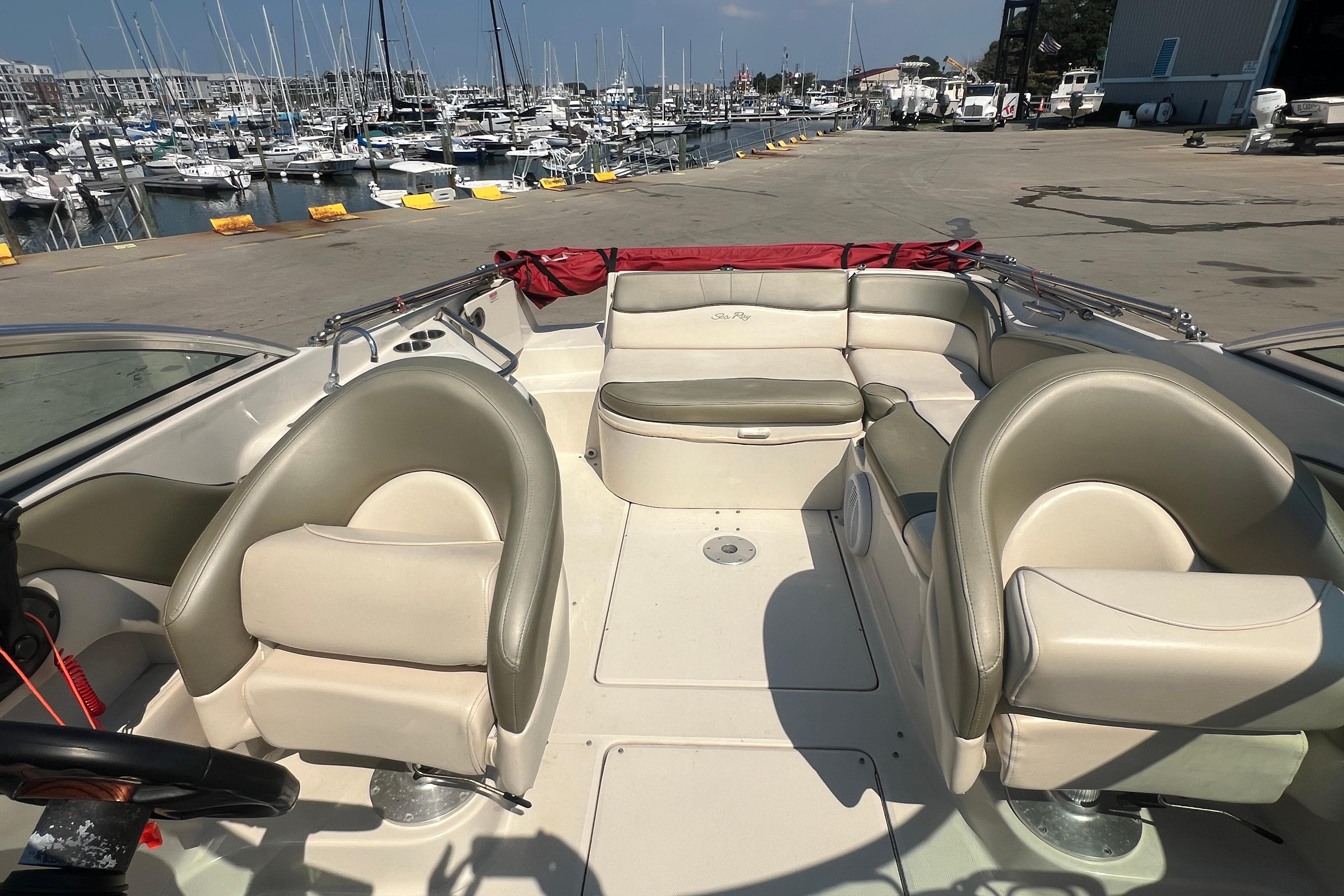 2005 Sea Ray 240 Sundeck interior with beige seating, docked at a marina.