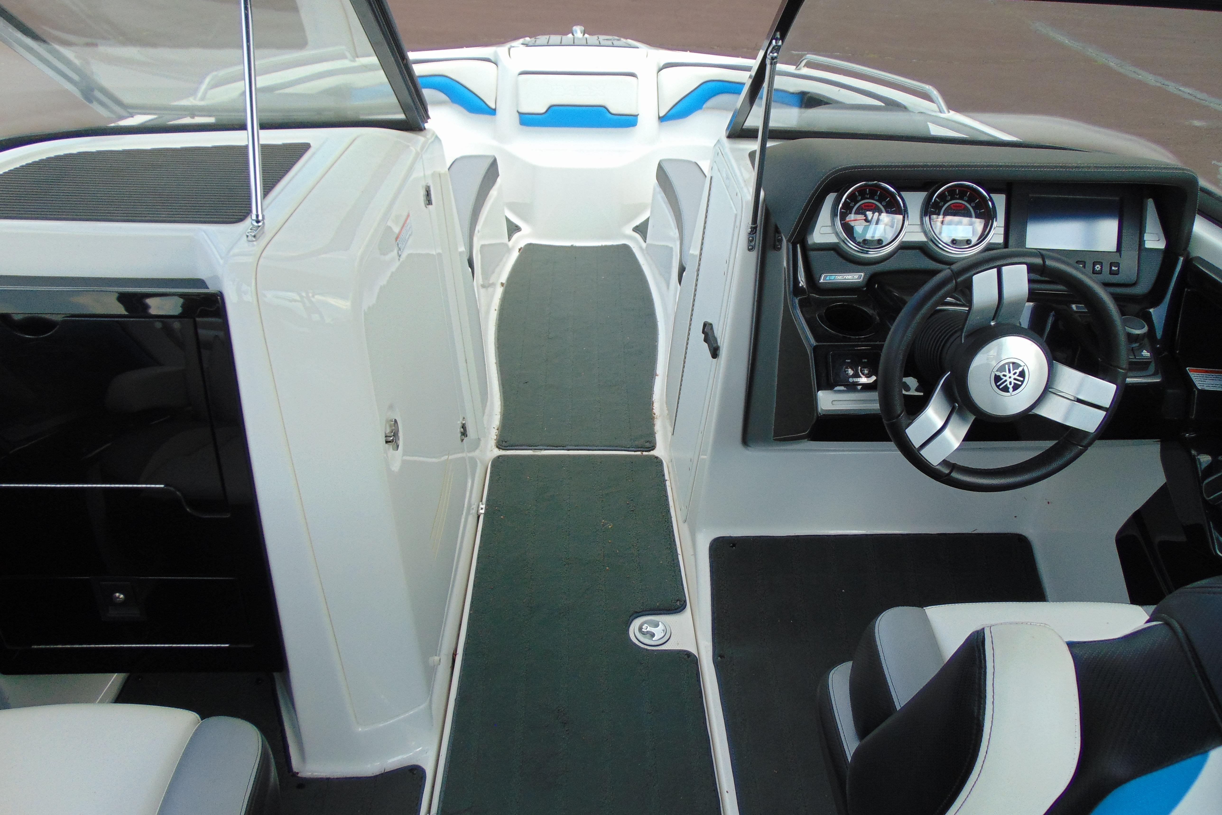 Interior view of a 2016 Yamaha Boats 242X E-Series, showcasing the helm and seating area.