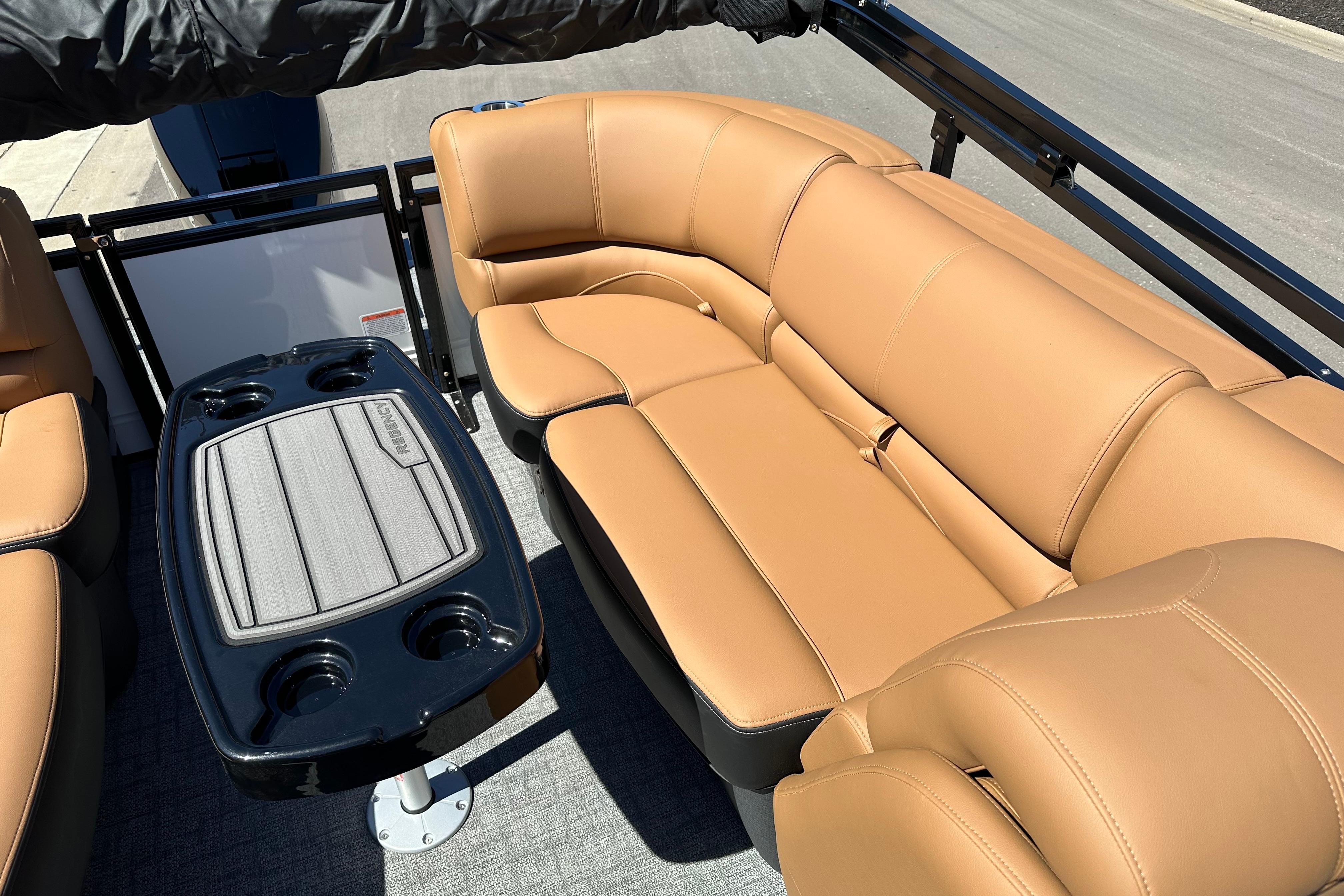 Luxurious seating on 2026 Regency 230 DL boat with tan upholstery and sleek table design.