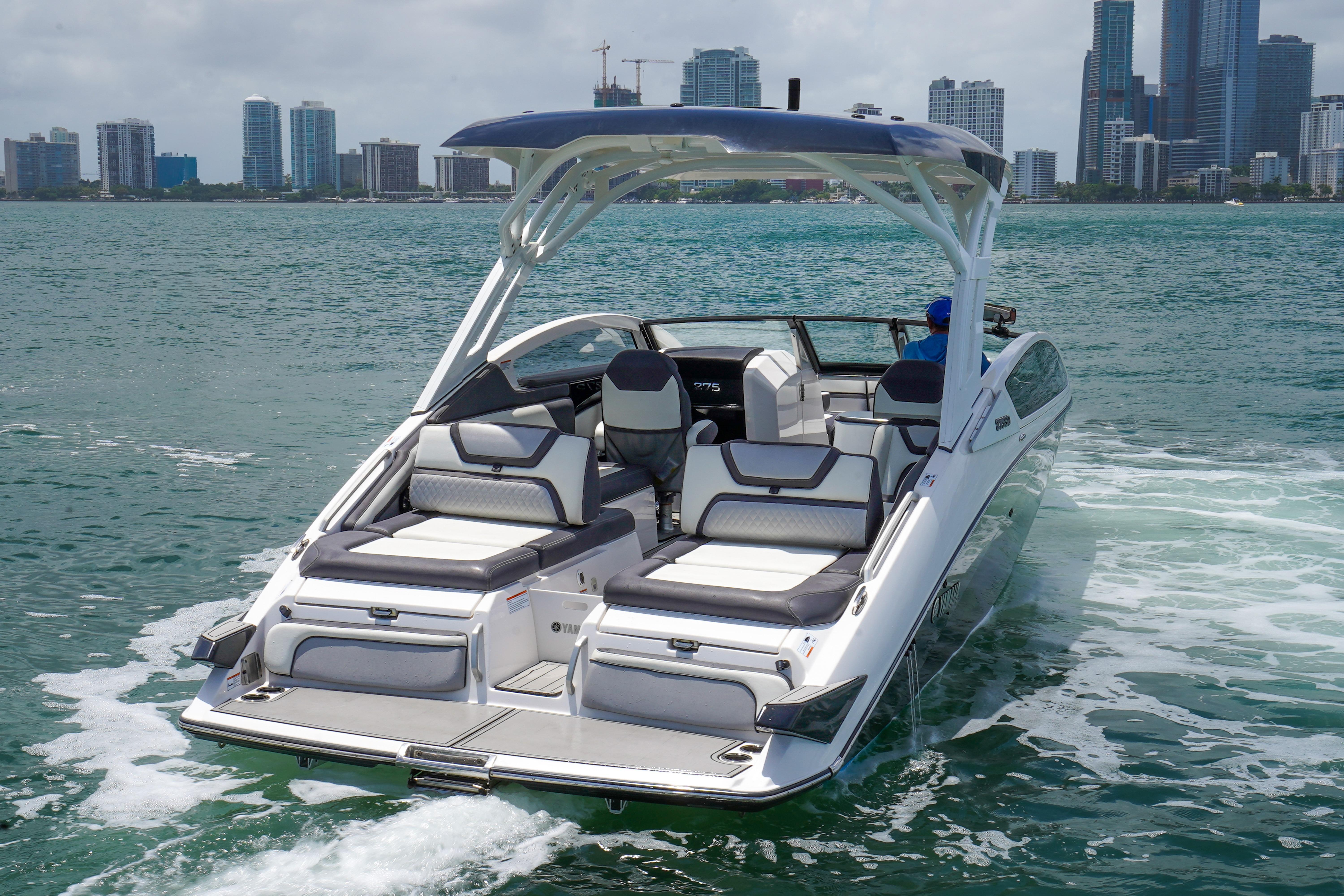 2021 Yamaha Boats 275SD cruising on water near city skyline.
