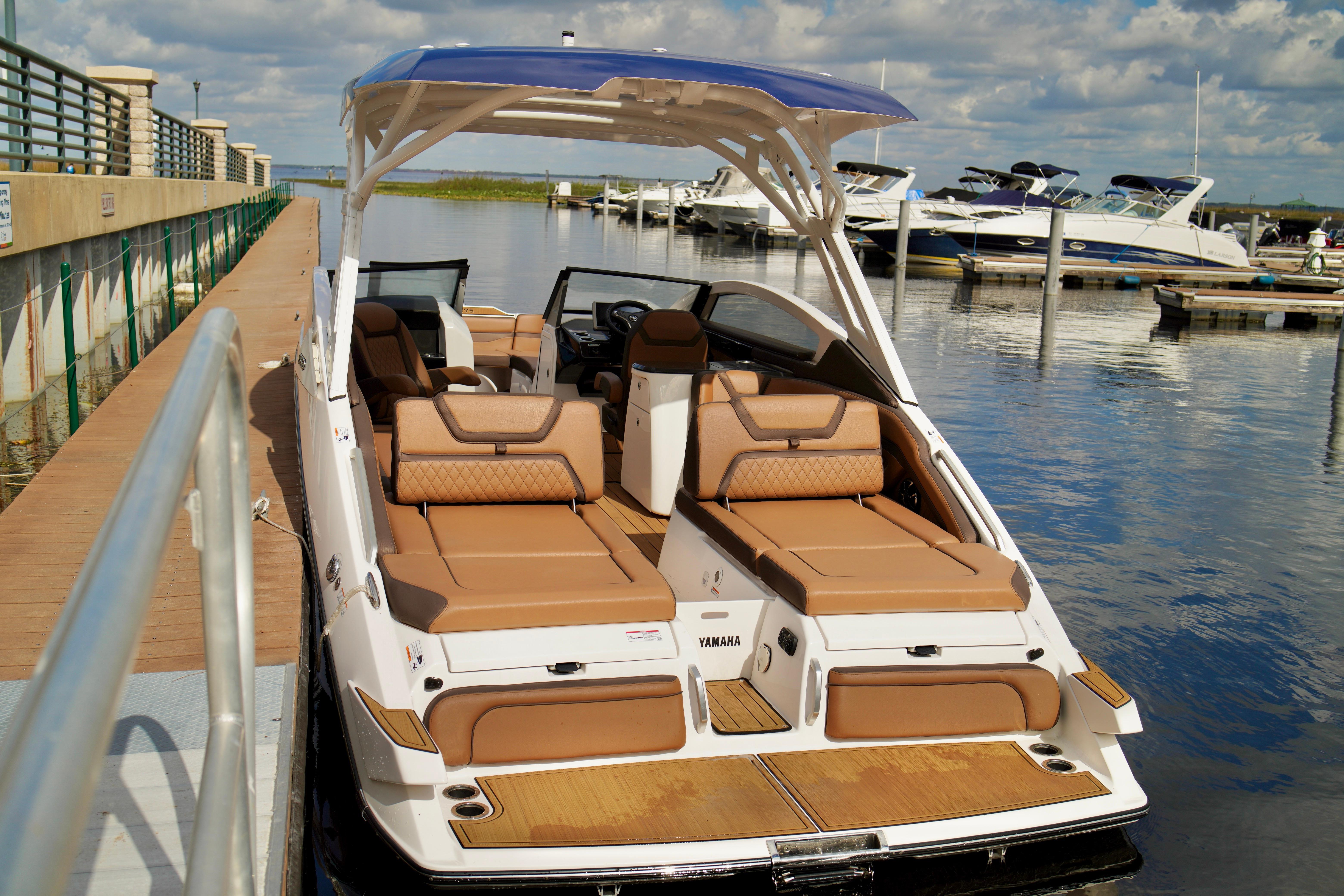 2025 Yamaha Boats 275SD docked, featuring luxurious seating and sleek design.