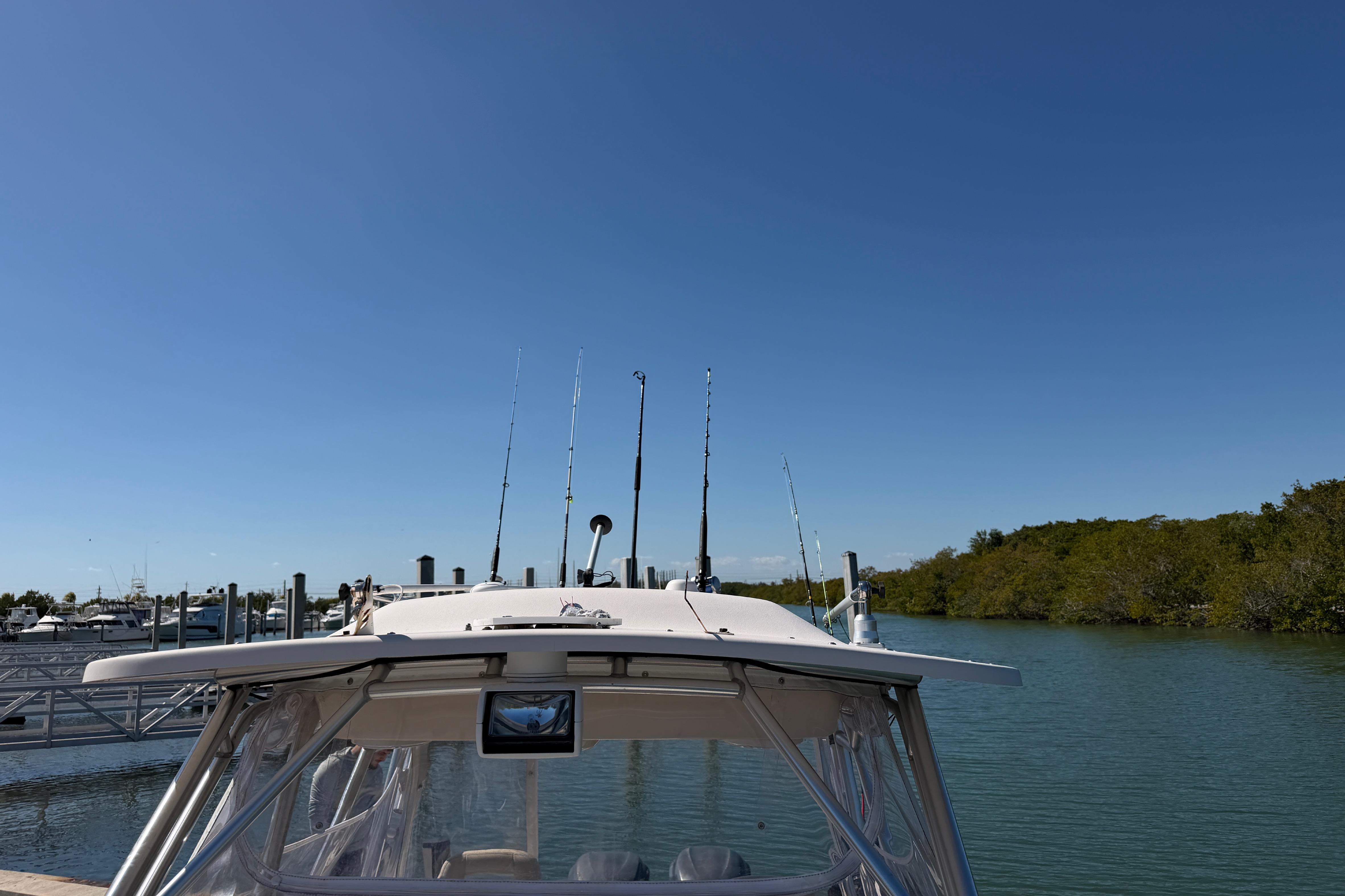2006 Grady-White Sailfish 282 boat docked by a serene waterway under clear blue skies.