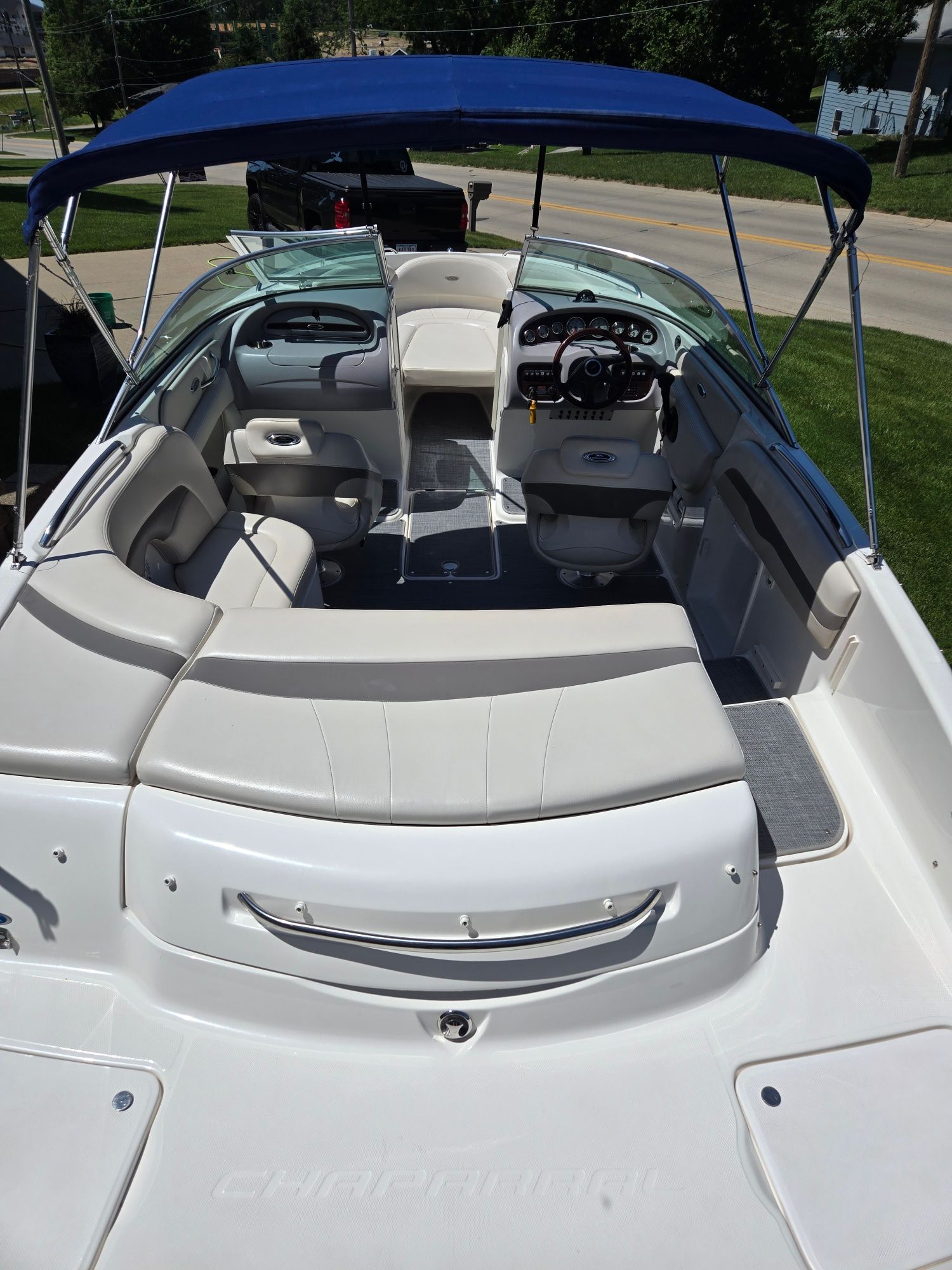 The image shows the cockpit of a 2005 Chaparral 220 SSi boat with a blue Bimini top.