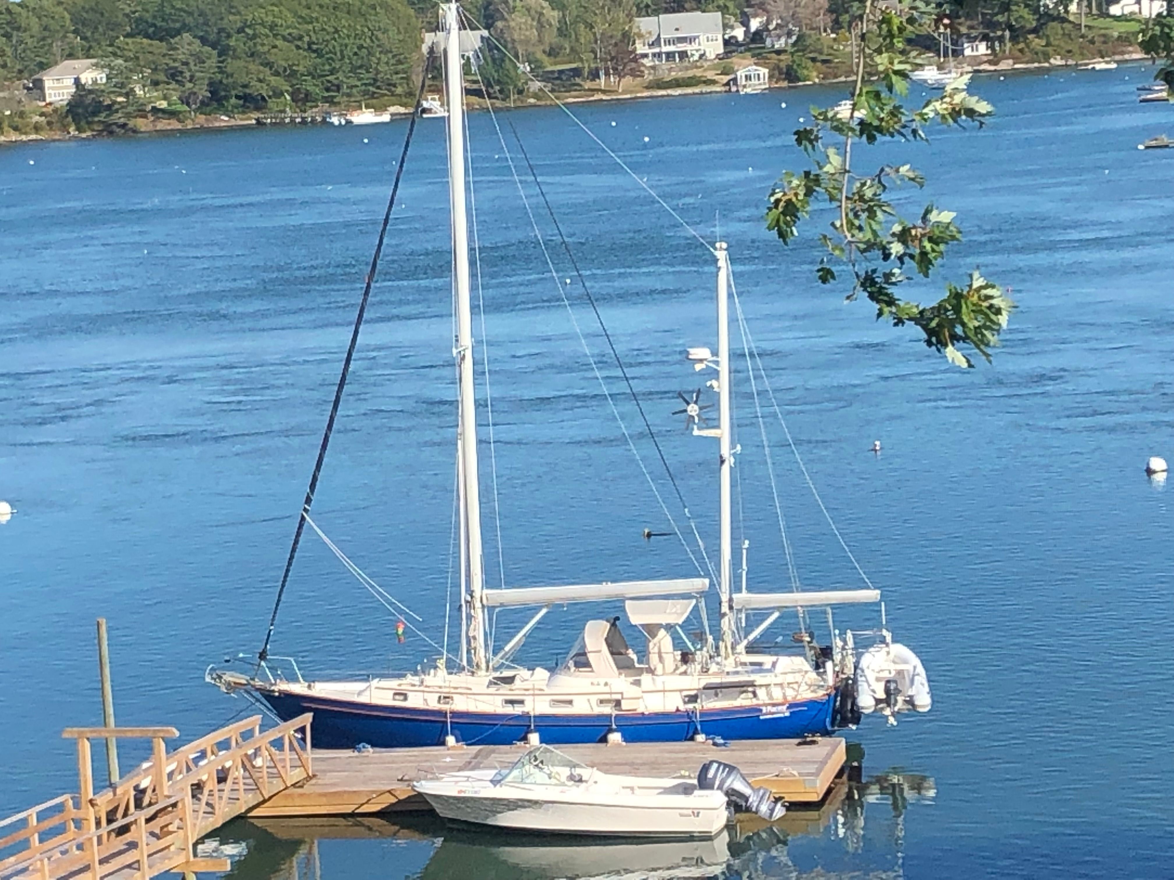 Sailboat and 1992 Wellcraft V Step docked on calm water.