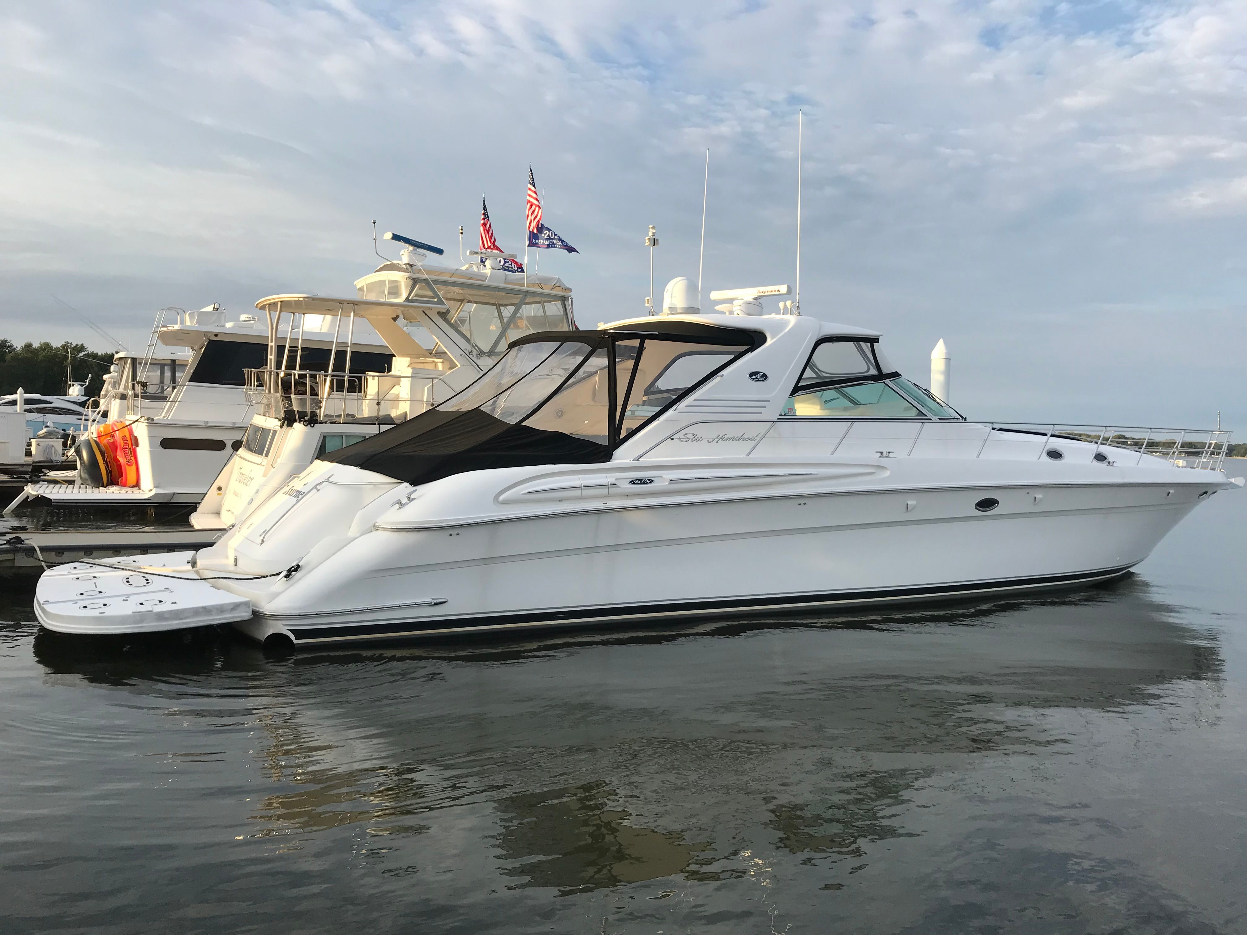 A 2003 Sea Ray S600 Sunsport is docked in the water, surrounded by other boats.