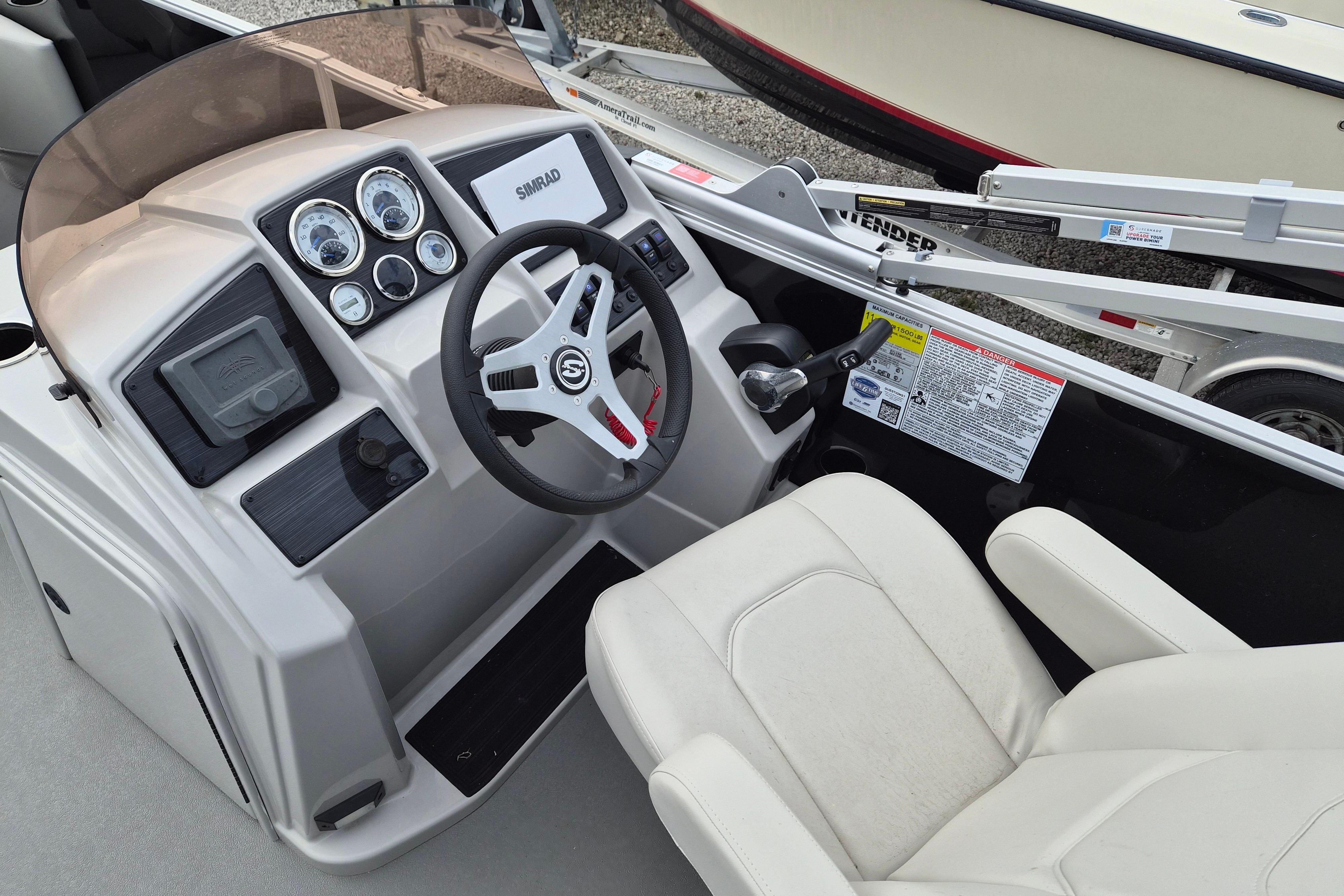 Cockpit of 2025 Sylvan Mirage Fish 8522 Party Fish 4.0 with steering wheel and controls.