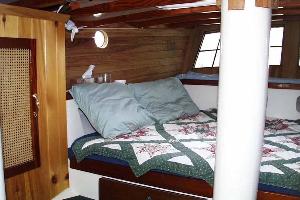Cozy cabin interior of 2002 Parker Marine Lorcha 50 with quilted bedding and wooden accents.