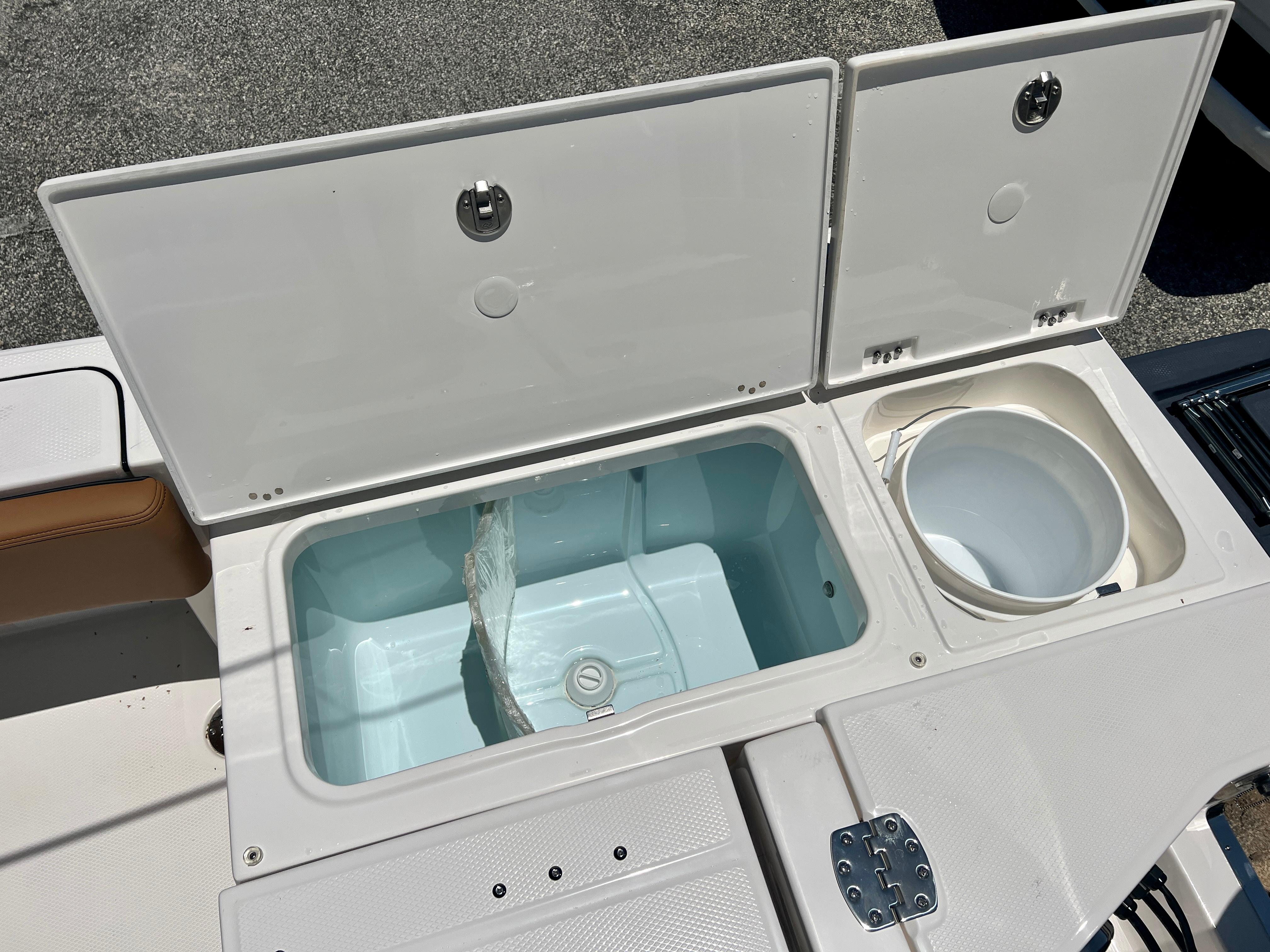 Robalo 266 Cayman 2025 boat with open storage compartments and bucket.