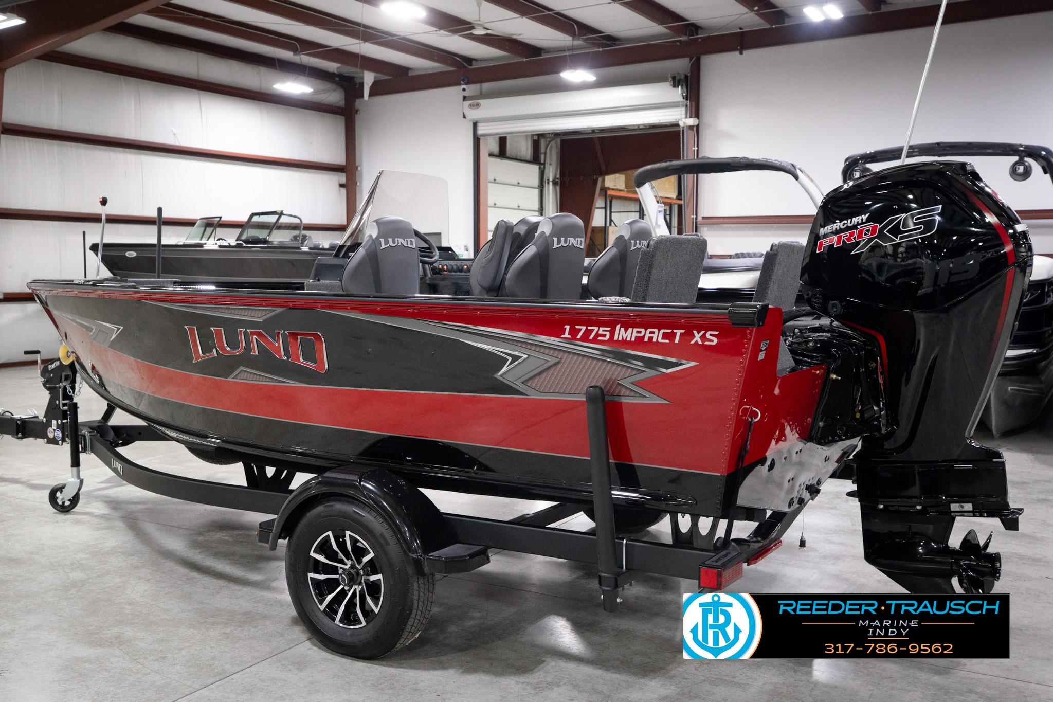2026 Lund 1775 Impact XS SS boat in showroom, featuring sleek red and black design.