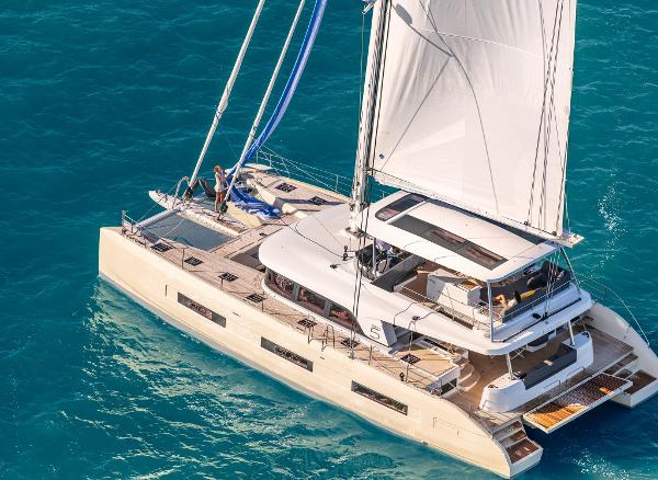 2025 Lagoon SIXTY 5 catamaran sailing on clear blue waters.