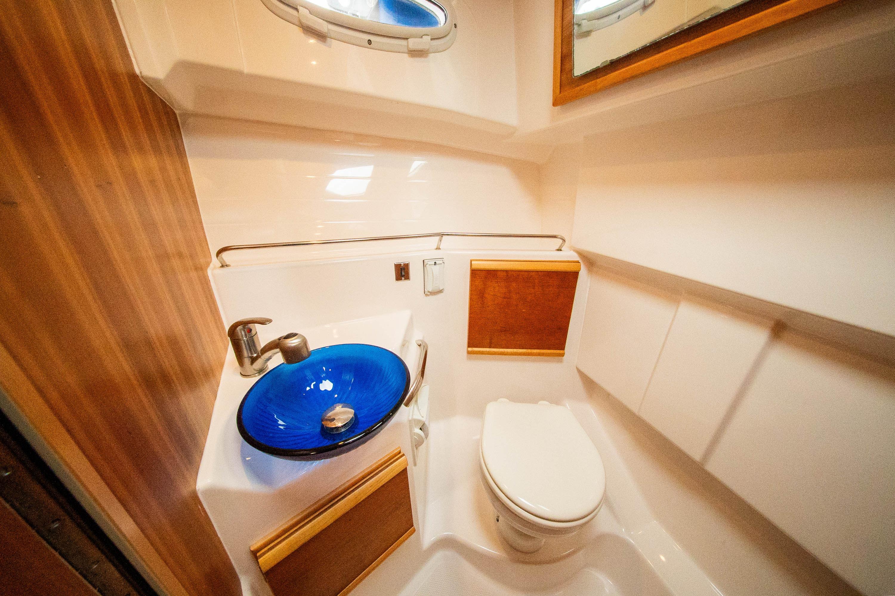 2019 Cutwater C-28 LE boat bathroom with blue glass sink and modern fixtures.