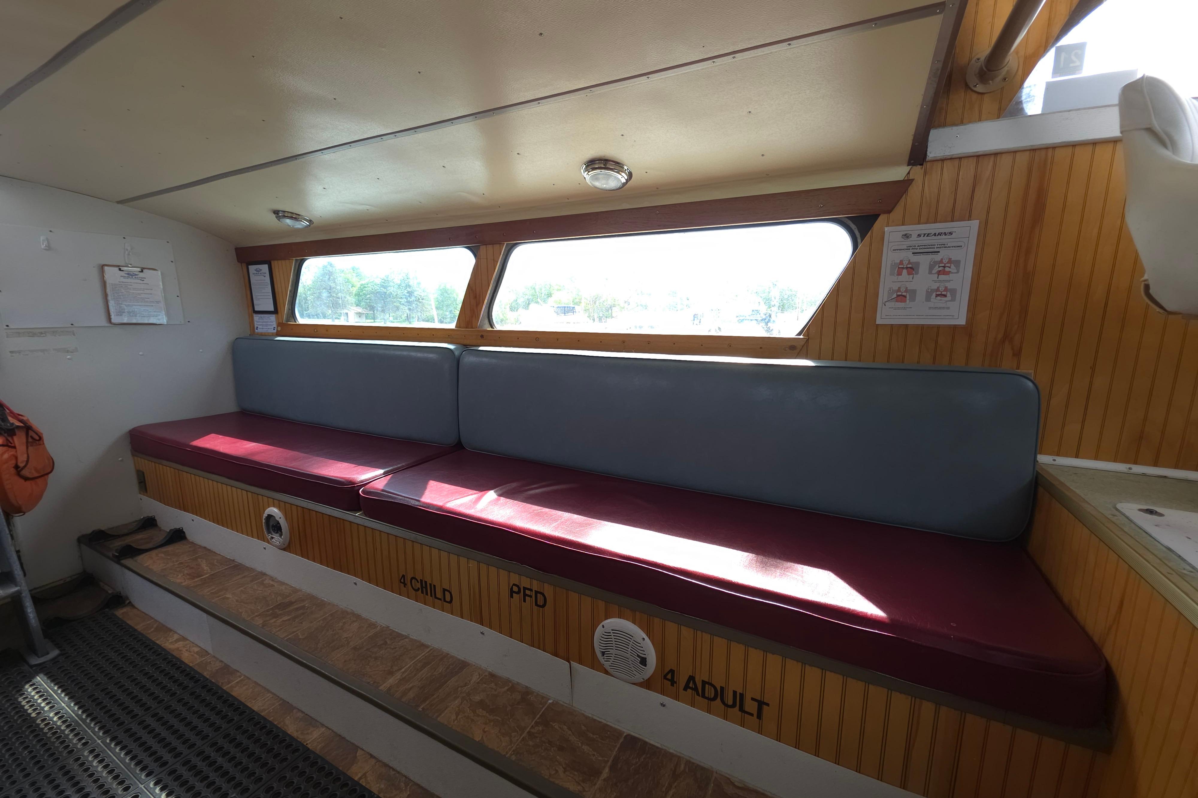 Interior of a 1974 Breaux's Bay Craft passenger boat with seating and safety instructions.