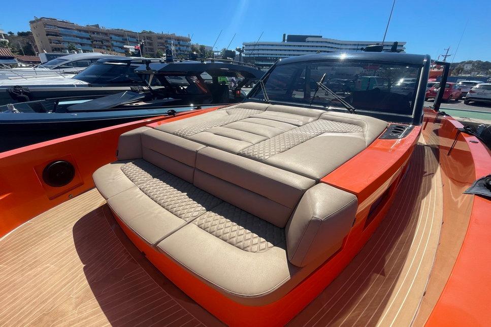 2022 Vanquish Yachts VQ52 luxury yacht with orange exterior and beige seating.