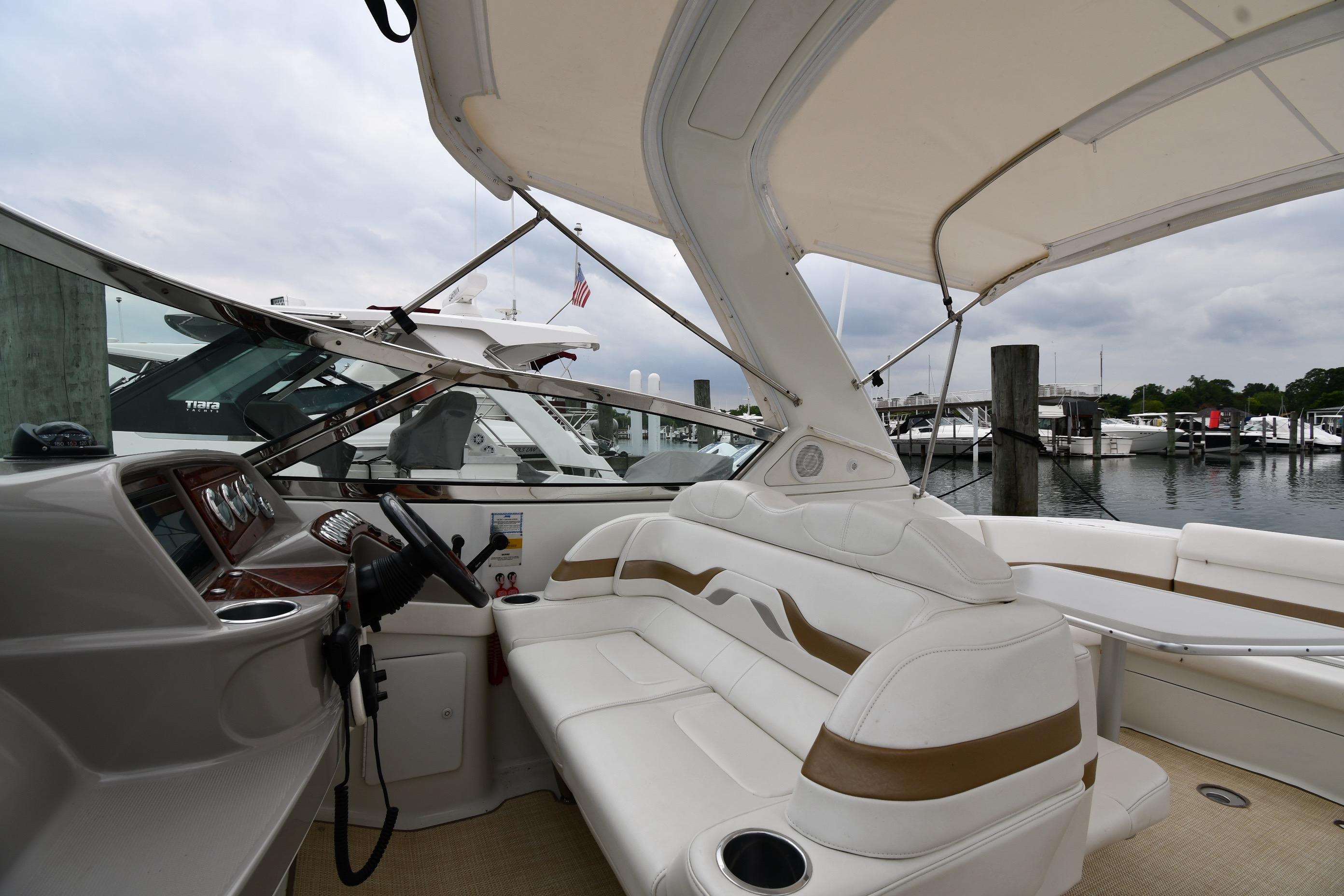 2004 Formula 330 Sun Sport boat interior at marina, featuring white seating and helm.