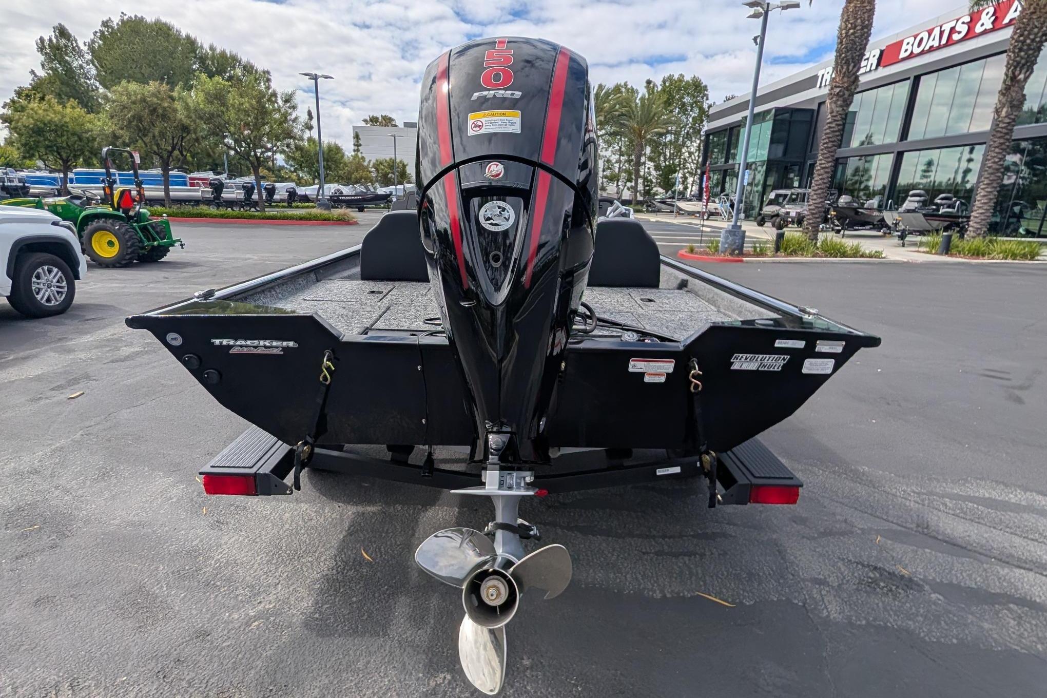 2026 Tracker Pro Team 195 boat with powerful outboard motor in dealership lot.