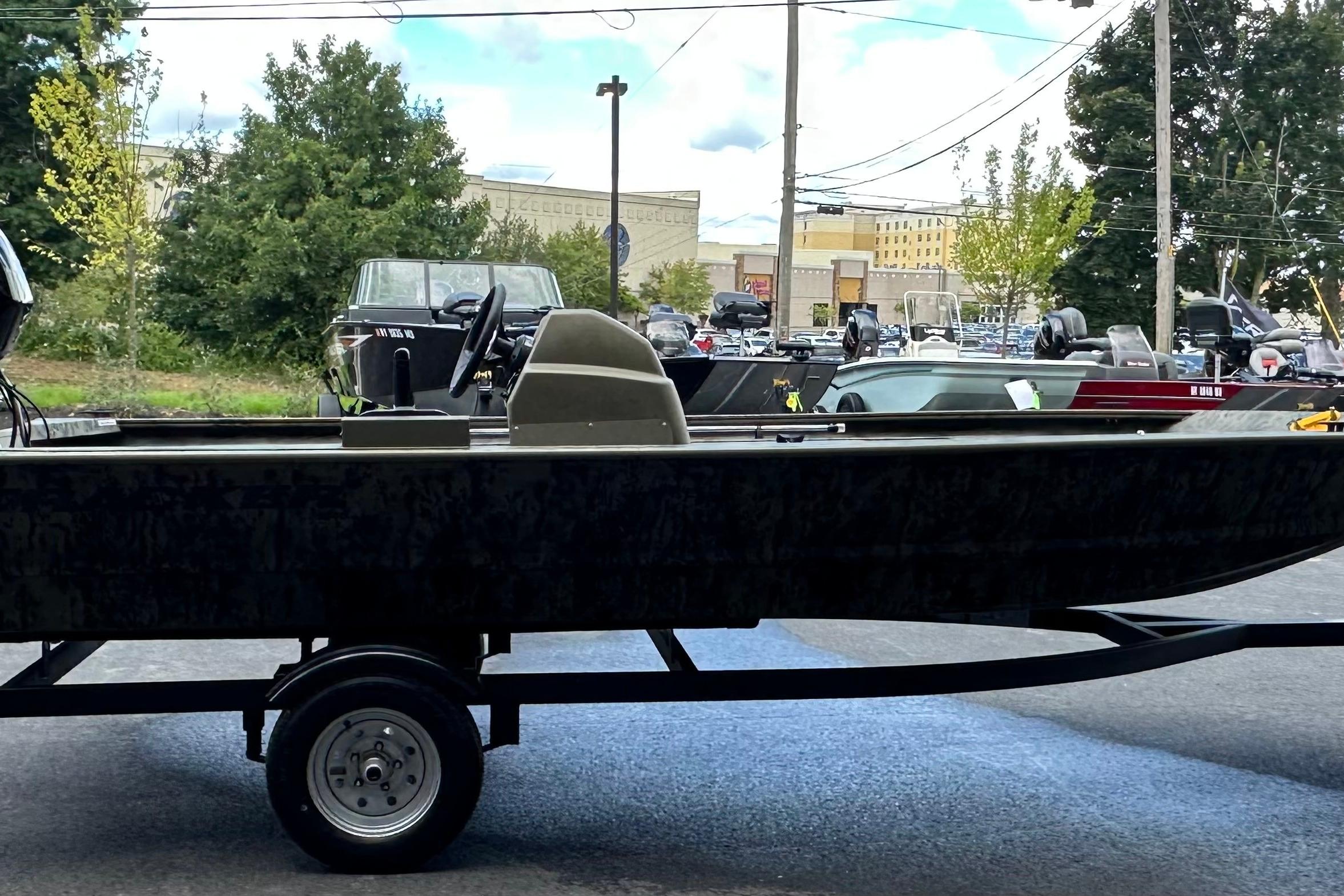 2026 Tracker Grizzly 1648 SC boat on trailer, parked outdoors.