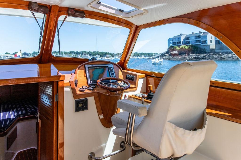 Interior of 2000 Hinckley Picnic Boat 36 Classic with wooden dashboard and scenic water view.