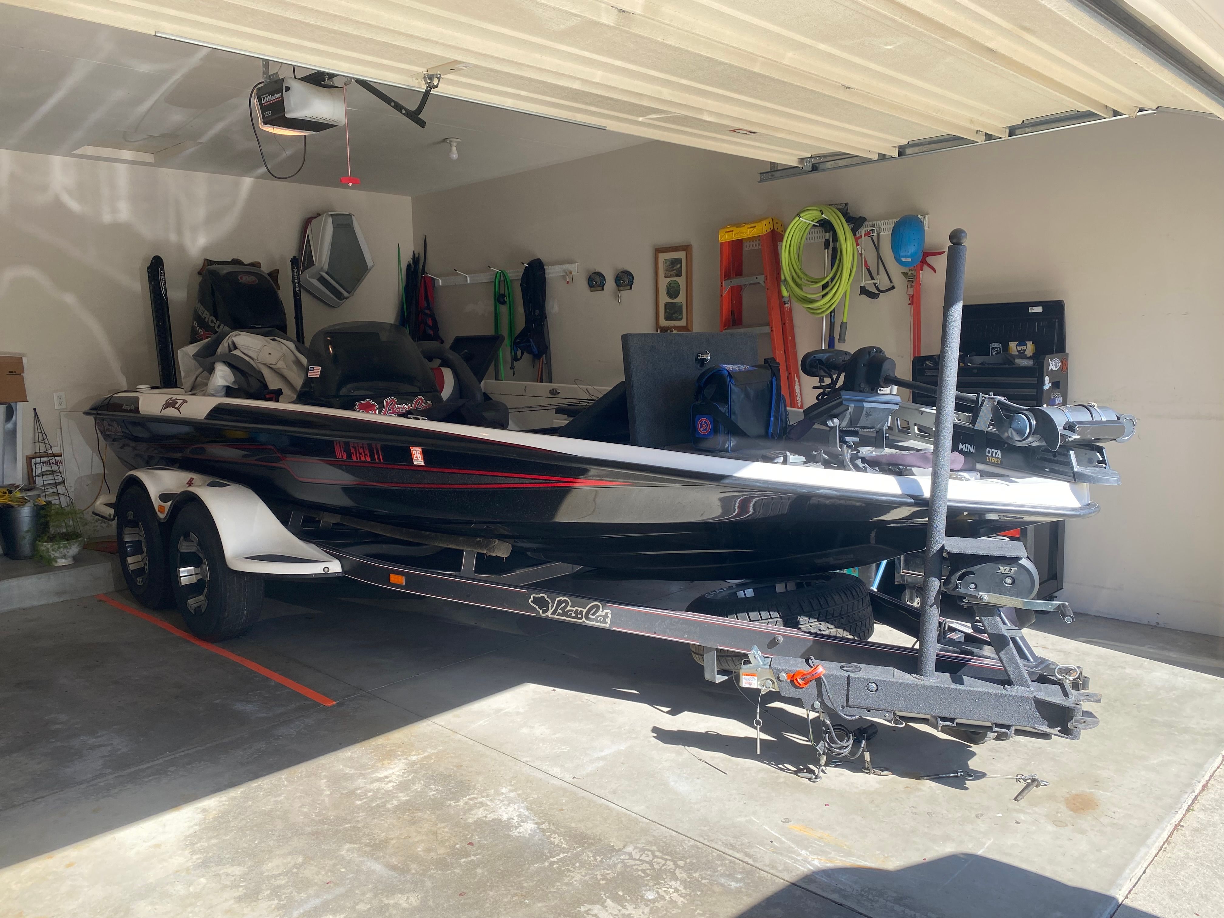 A 2014 Bass Cat Pantera II boat is parked in a garage on a trailer.