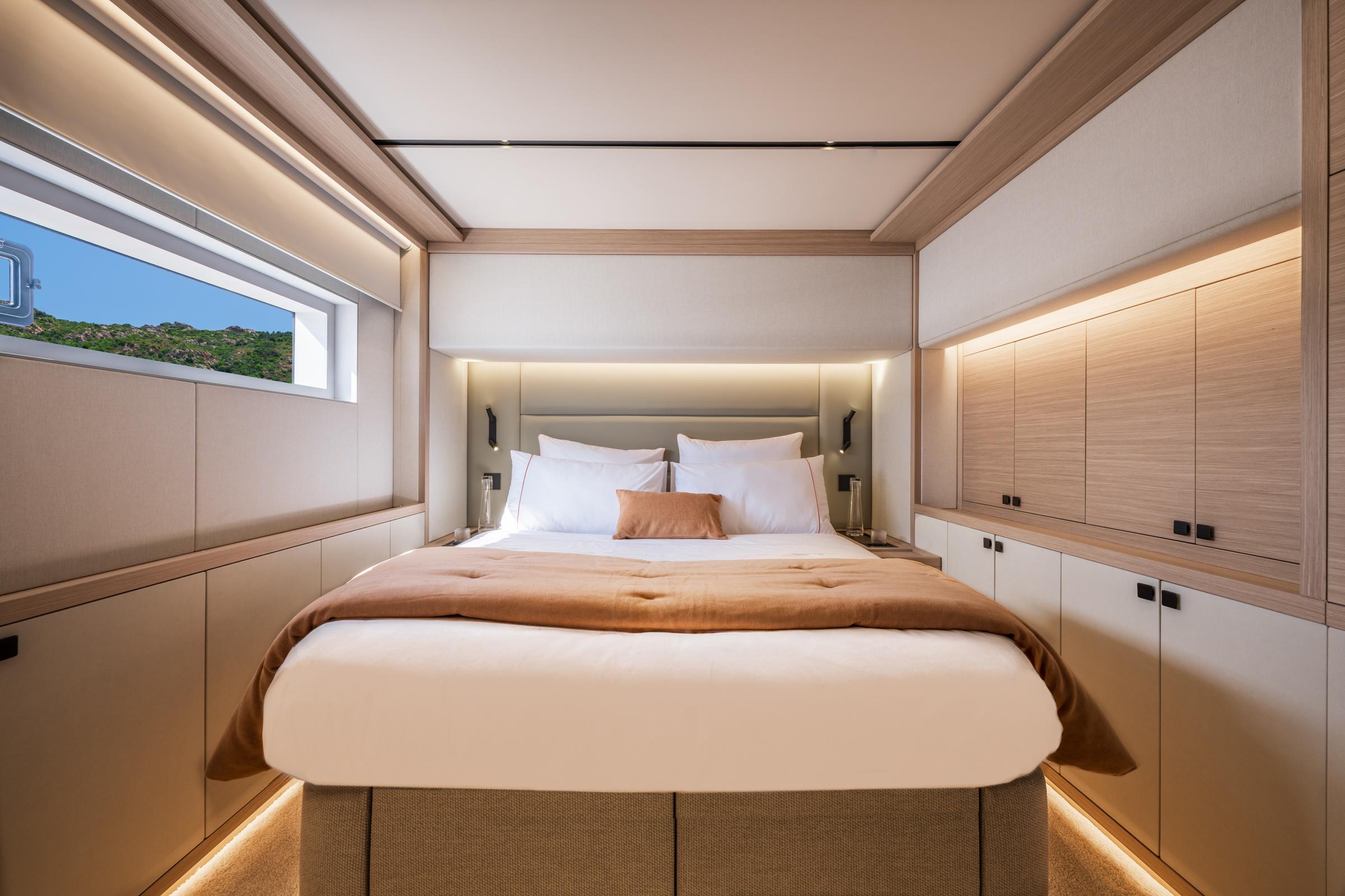 Luxurious bedroom interior of 2025 Lagoon Eighty 2 yacht with modern design and scenic window view.