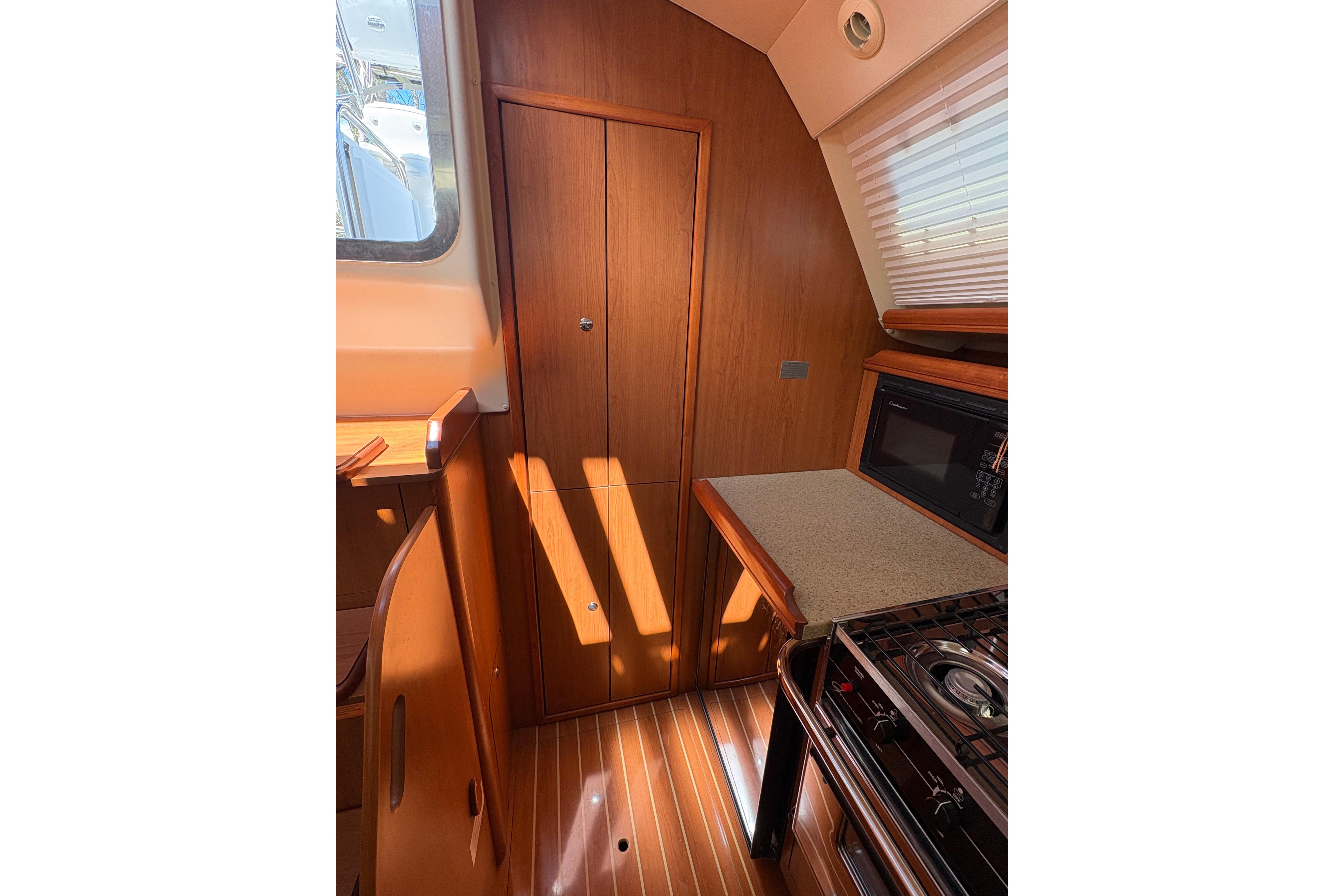 Interior of 2009 Hunter 41 Deck Salon, featuring wood cabinetry and kitchen appliances.
