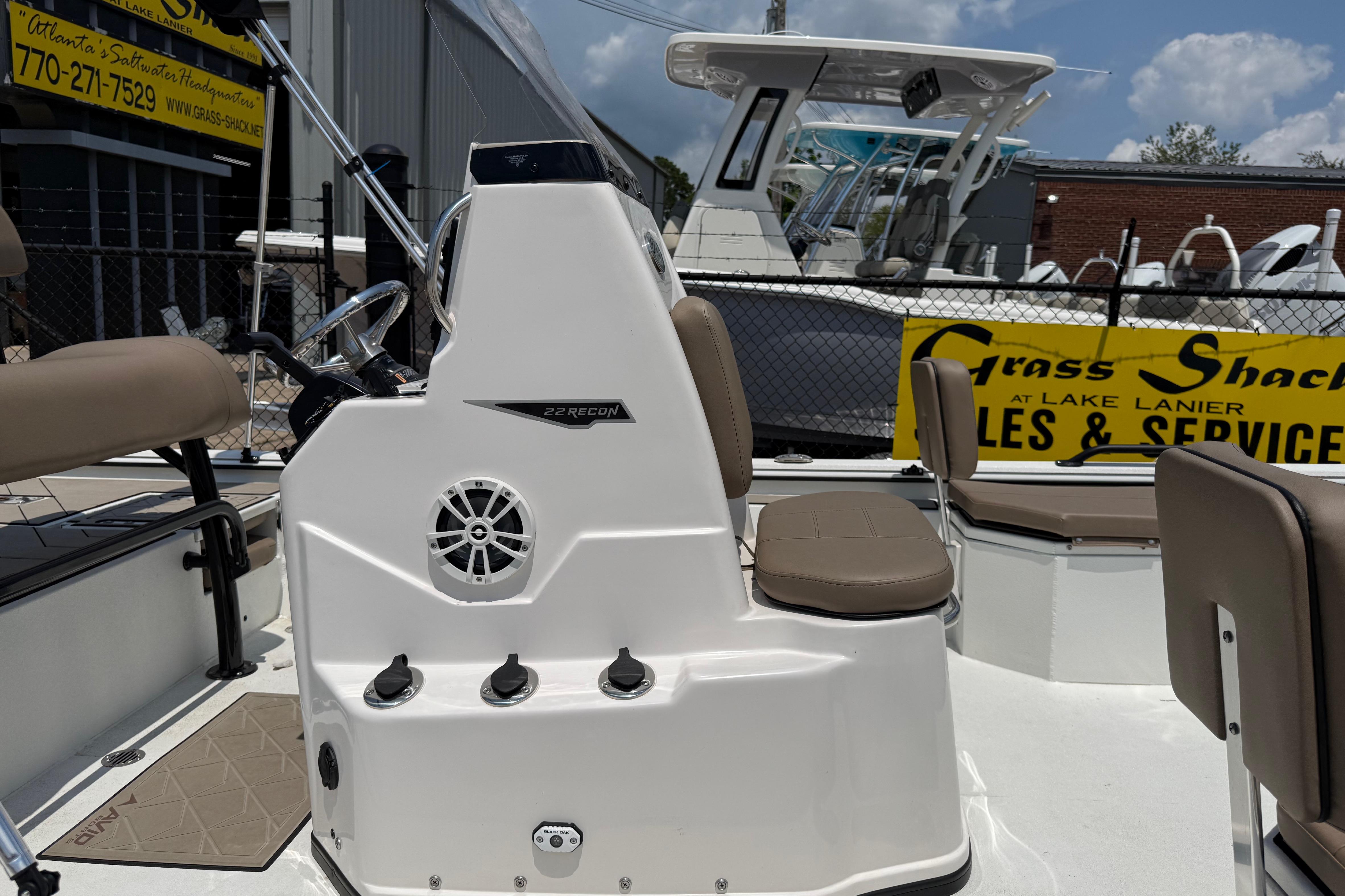2025 Avid 22 Recon boat interior with seating and control panel, displayed at a dealership.