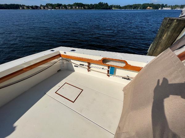 The image shows the stern of a boat with wood trim and a view of the water.
