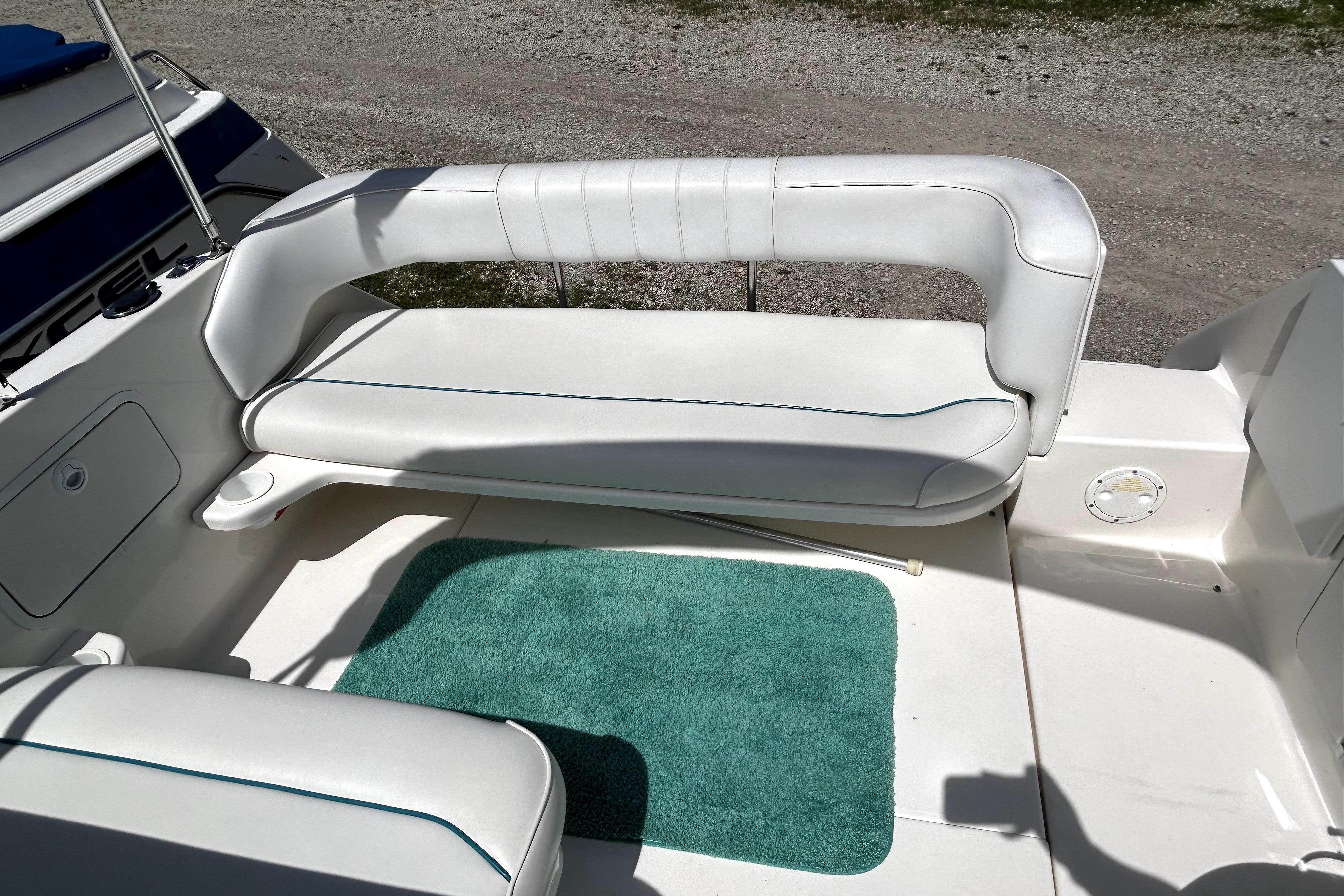 1995 Sea Ray 250 Sundancer boat interior with white seating and teal carpet.