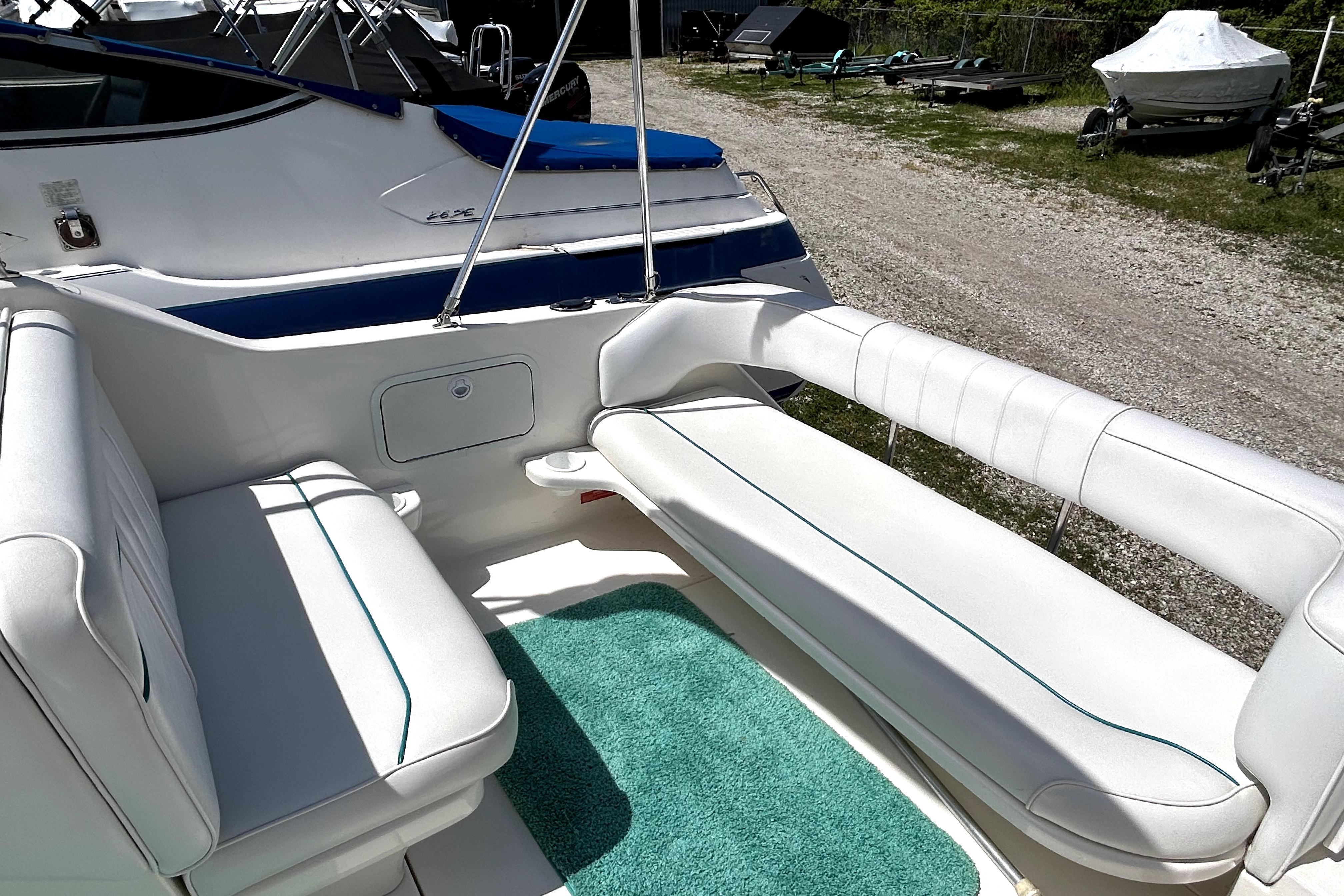 1995 Sea Ray 250 Sundancer boat interior with white seating and teal accents.