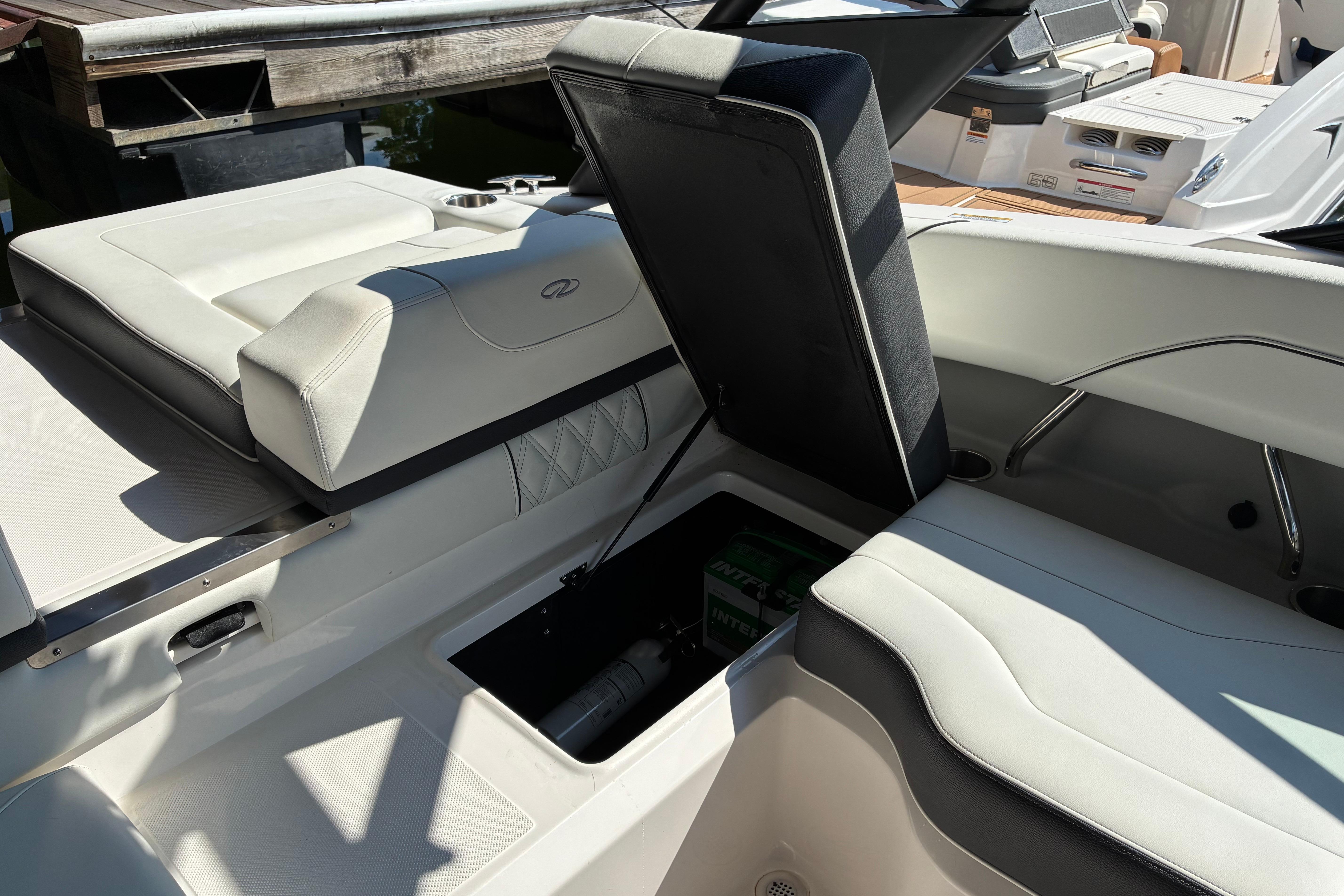 2025 Regal LS2 boat interior with open storage compartment, showcasing sleek white seating.