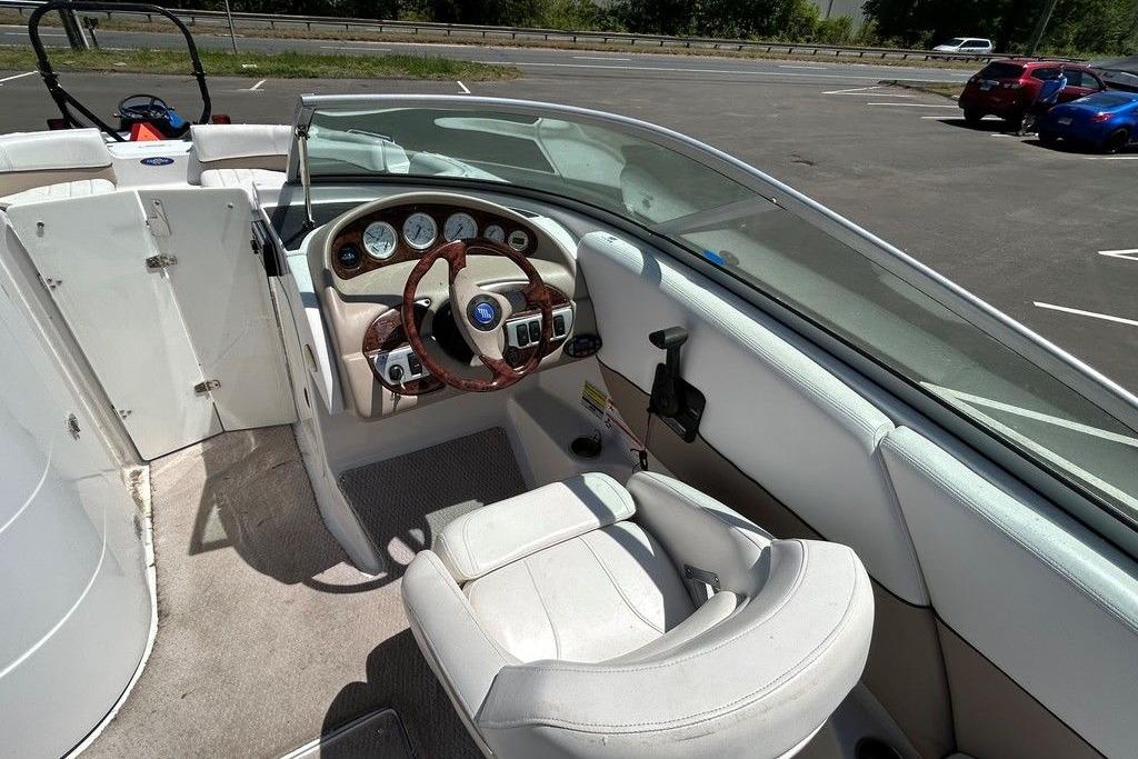 Interior of 2006 Four Winns 244 Funship boat with steering wheel and dashboard.