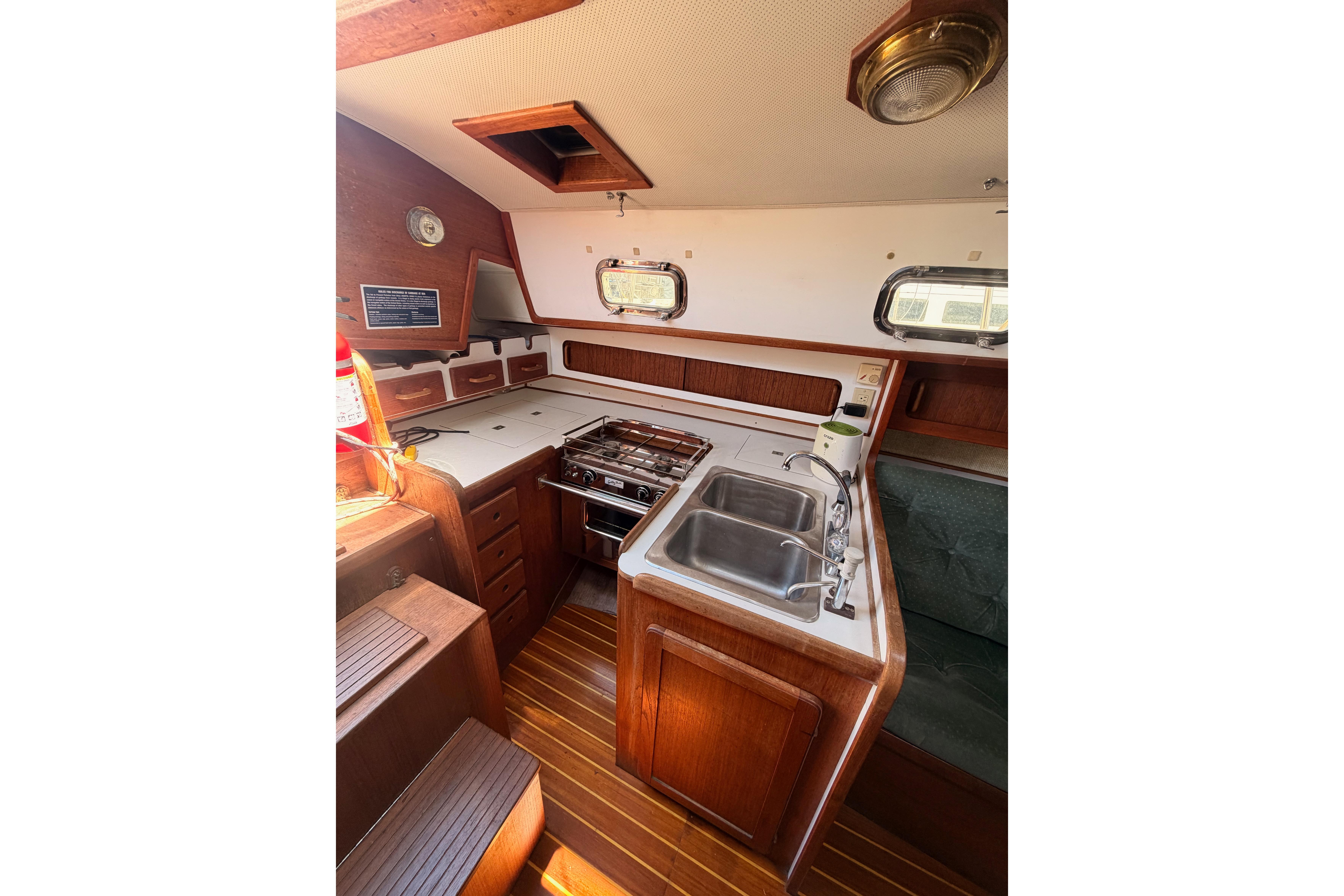 1991 Caliber 33 yacht interior with wooden cabinetry, dual sink, and stove in the galley.