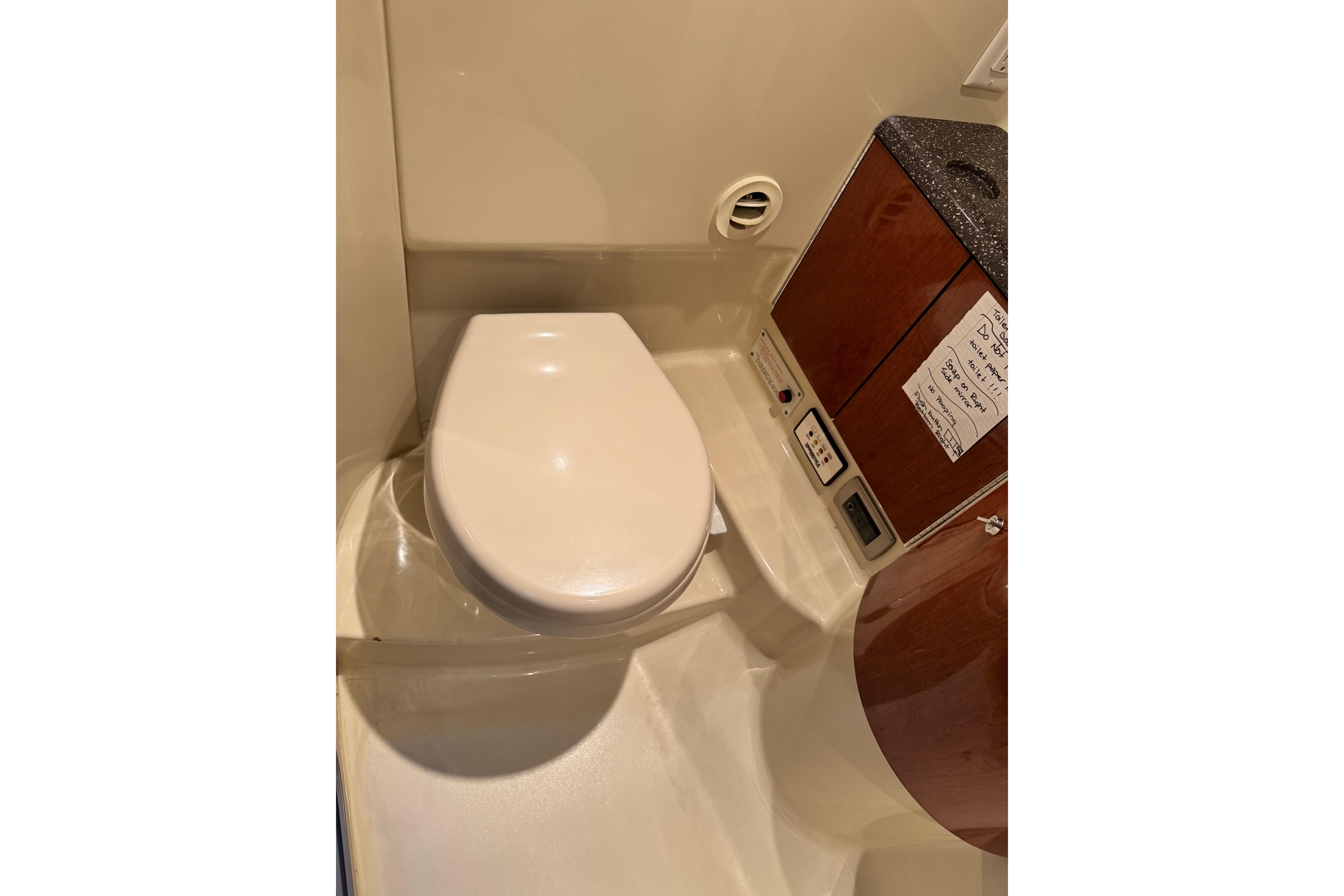 2008 Formula 400 Super Sport boat bathroom with toilet and wooden cabinetry.