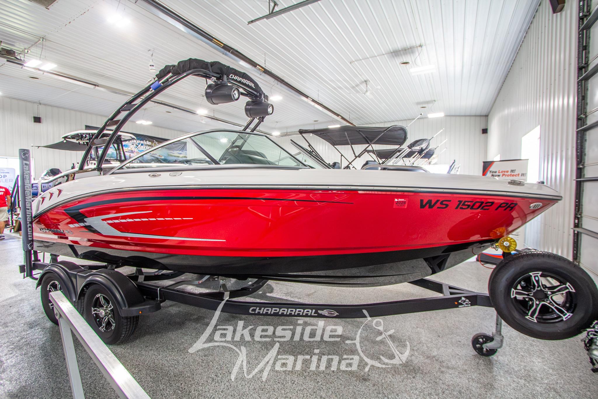 2022 Chaparral 21 SSi boat in showroom, red and white design, on trailer.